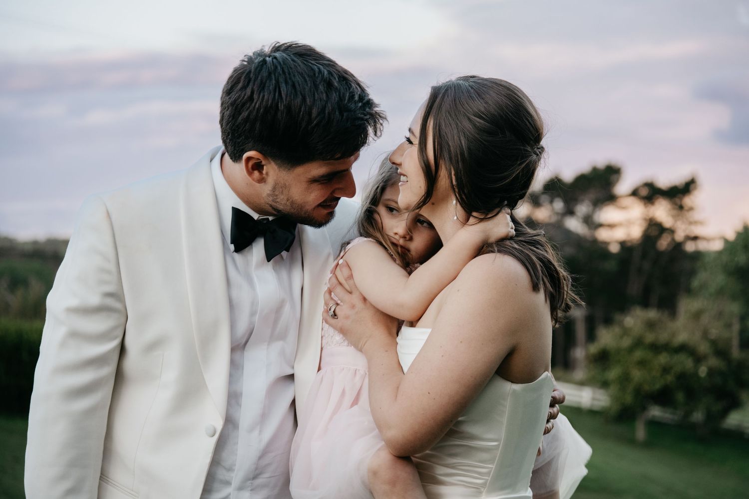 A romantic outdoor wedding photo series showing intimate moments between newlyweds at sunset.