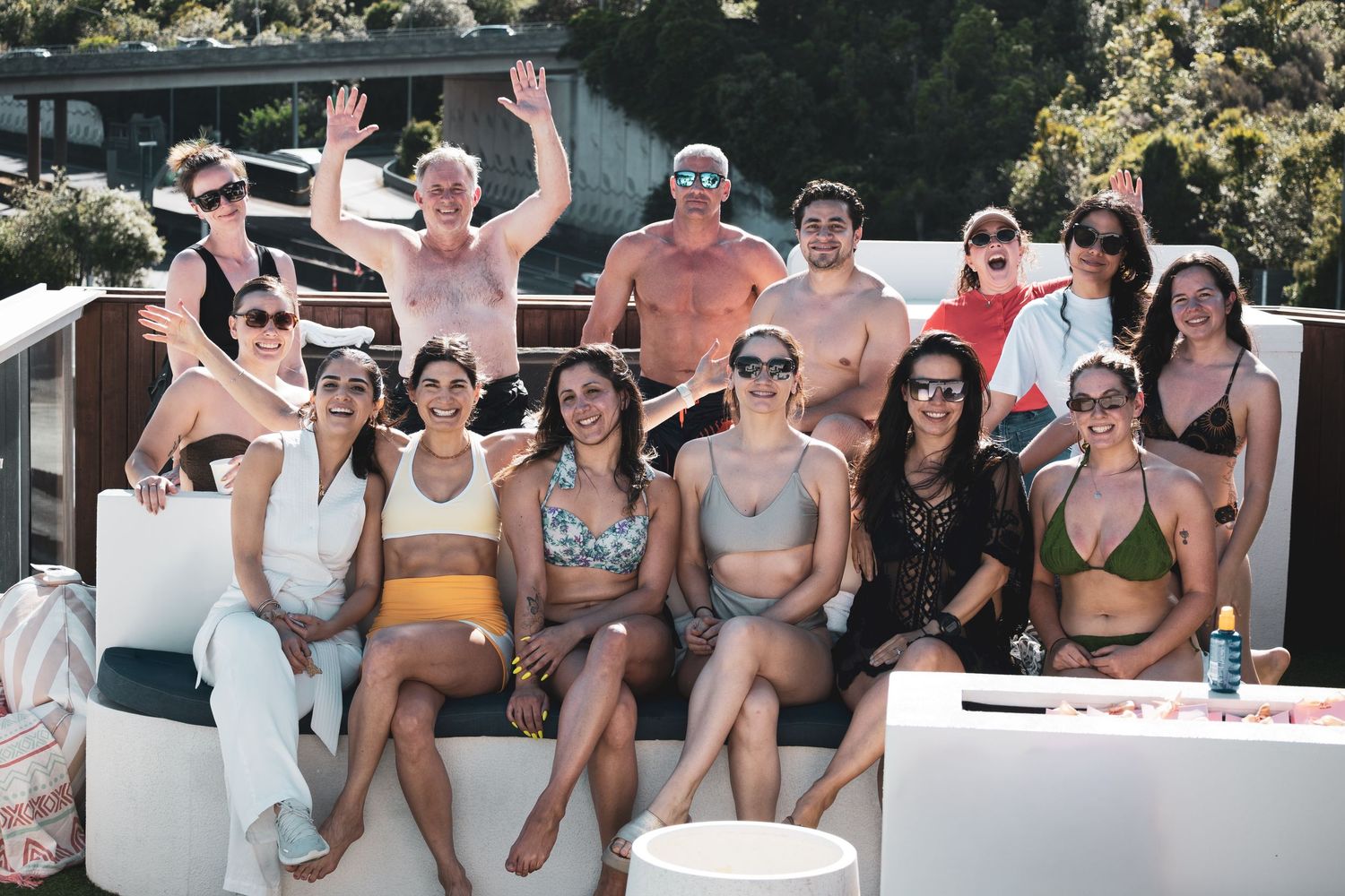 Group of friends enjoying a summer boat trip while relaxing and socializing on the deck in swimwear.