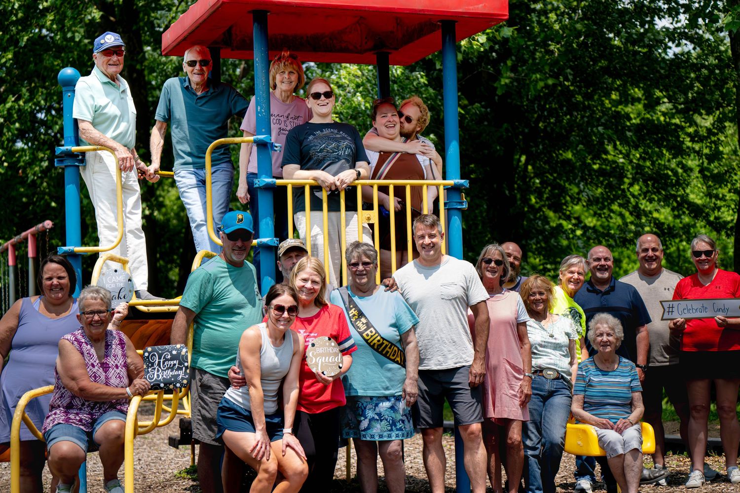 Spectators line the edge of a waterpark attraction watching and waiting for splashing action on a sunny summer day.