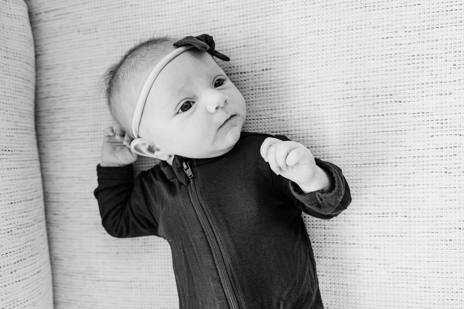 Black and white photo collage showing a baby in various poses wearing a dark outfit against a light background.