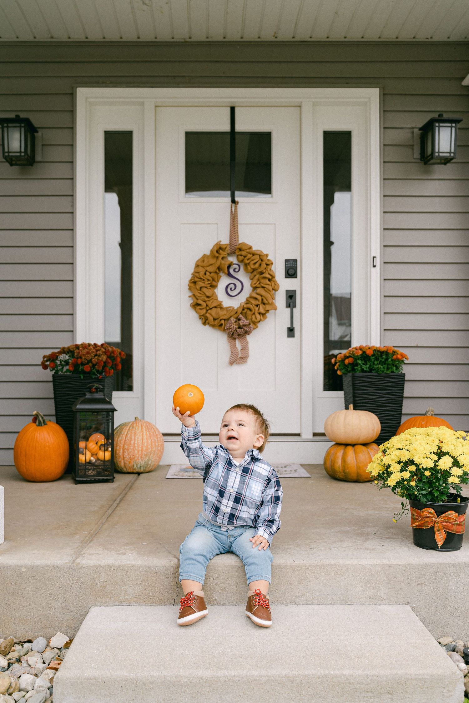 A fall-themed front porch decorated with pumpkins, mums, and a wreath shows seasonal outdoor moments.