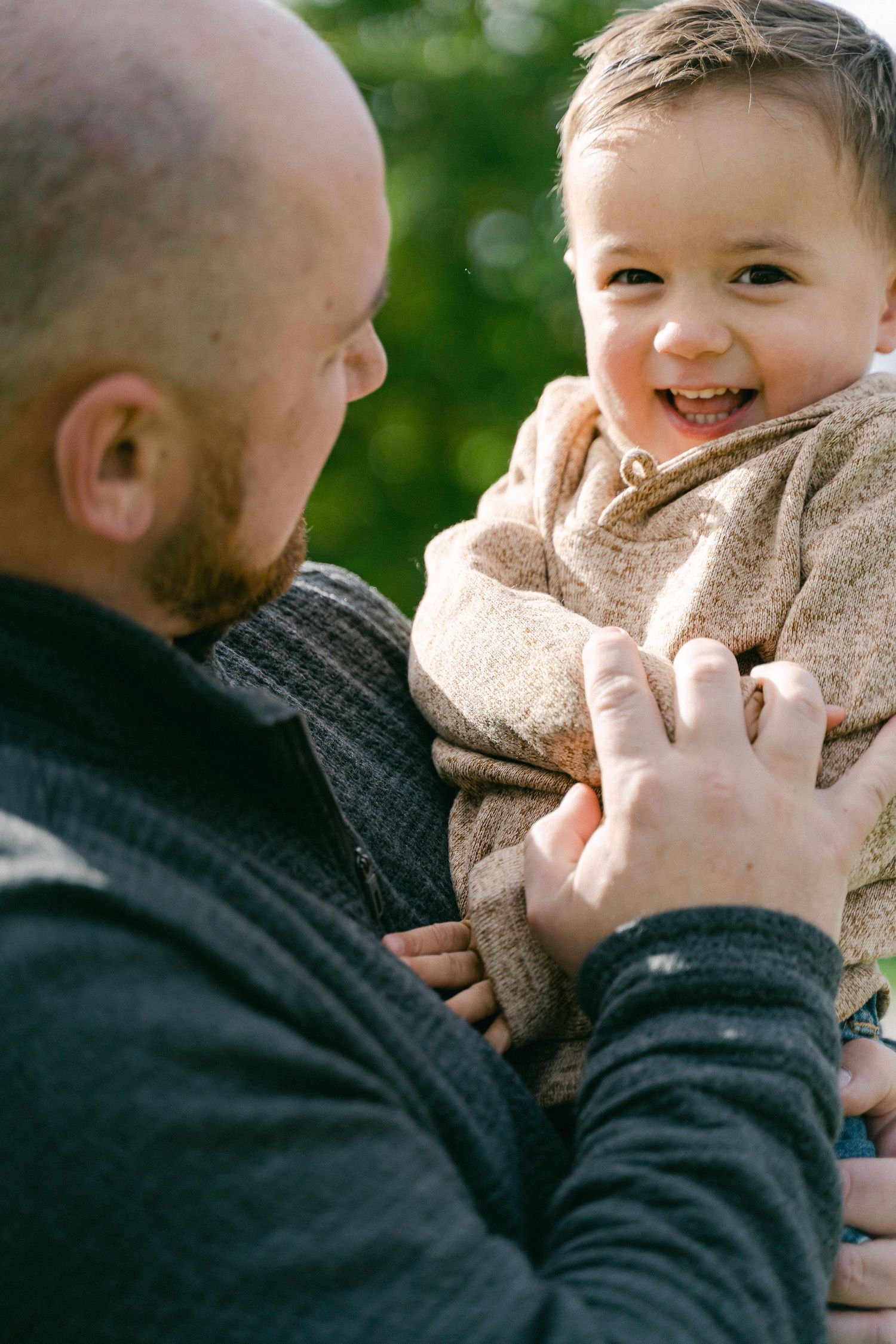 A series of candid photos showing tender moments between parent and baby against a green outdoor background.