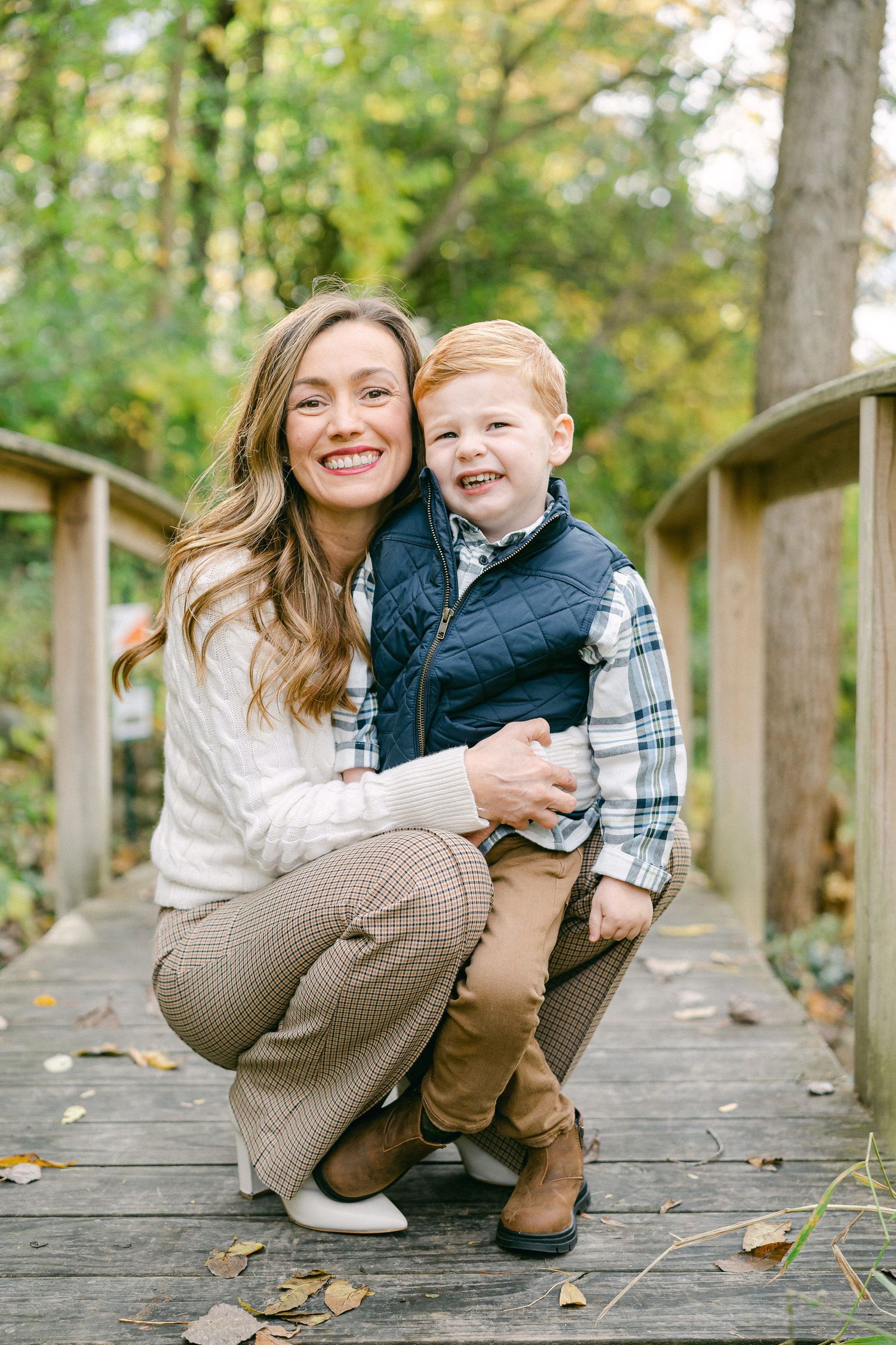 Candid moments shared on a rustic wooden bridge path during autumn.