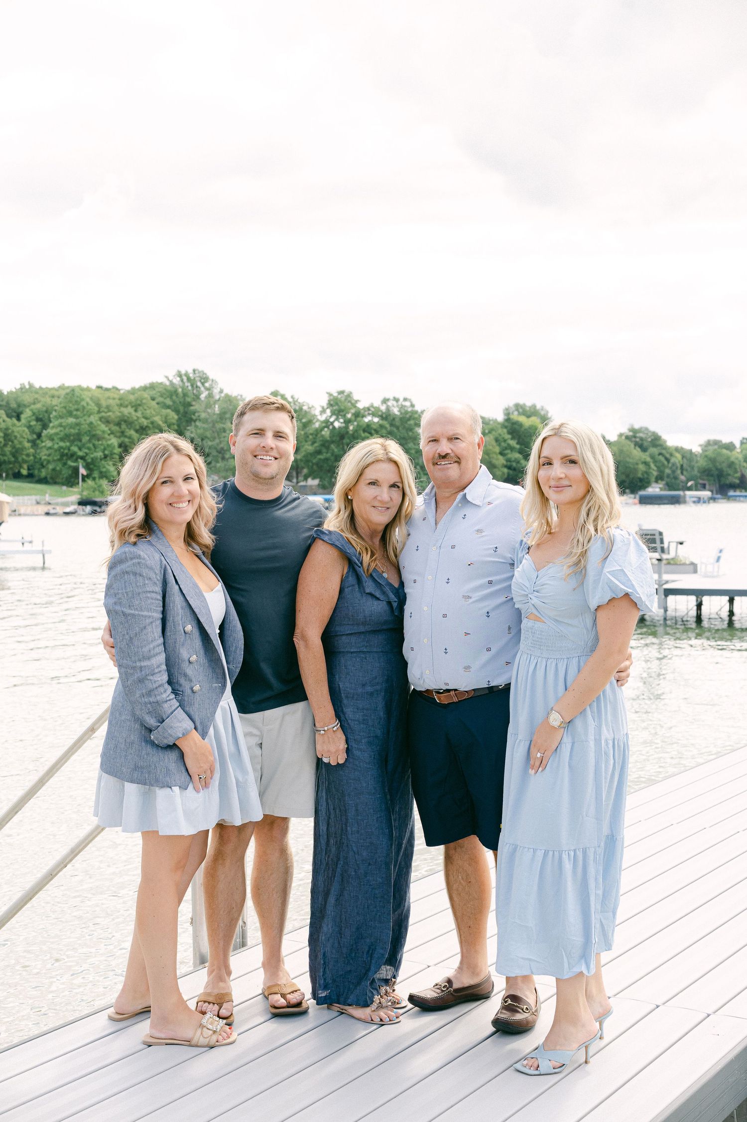 Family members standing together in coordinated blue and white outfits on a waterfront dock.