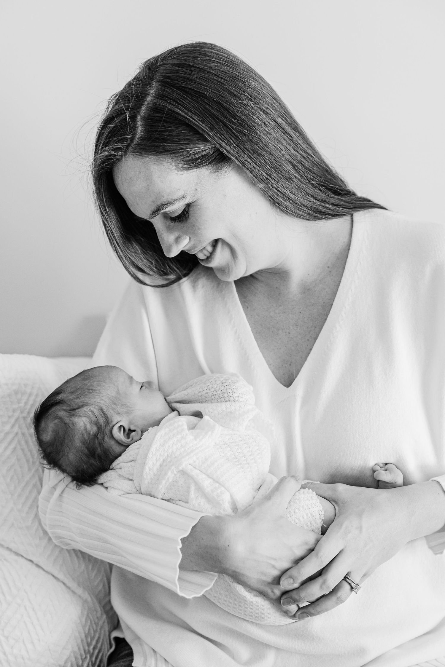 A tender black and white photo series of a mother cradling and bonding with her newborn baby.