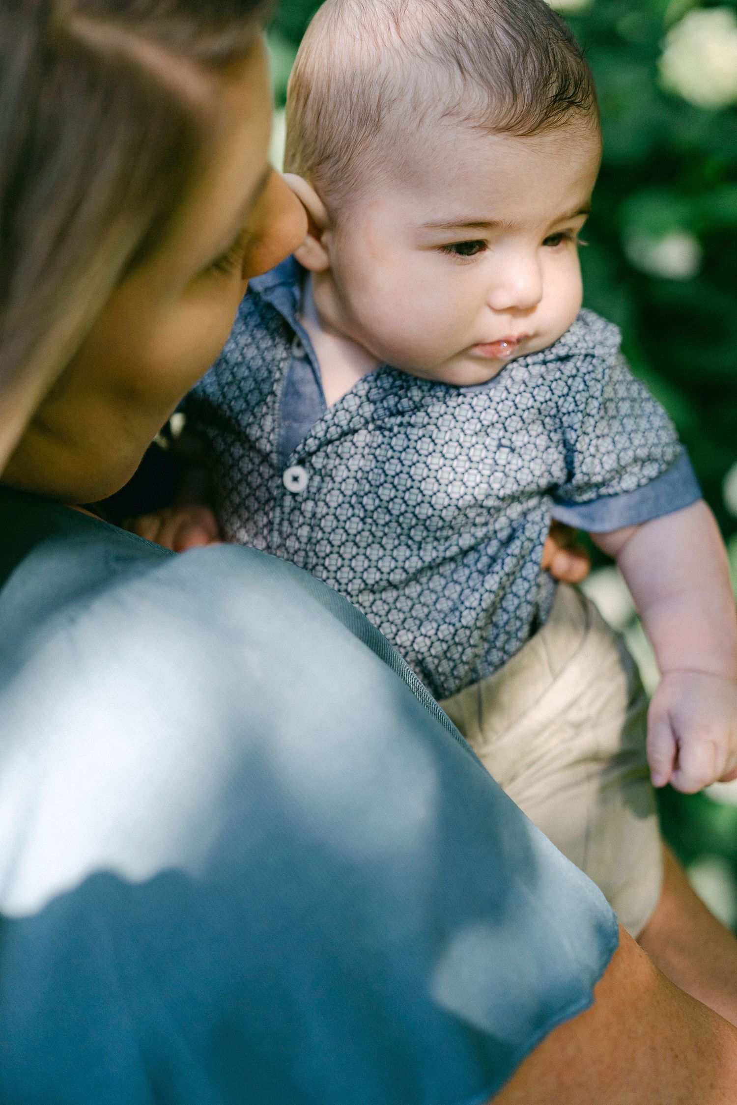 Close-up series of a baby in a patterned outfit being held and cuddled.