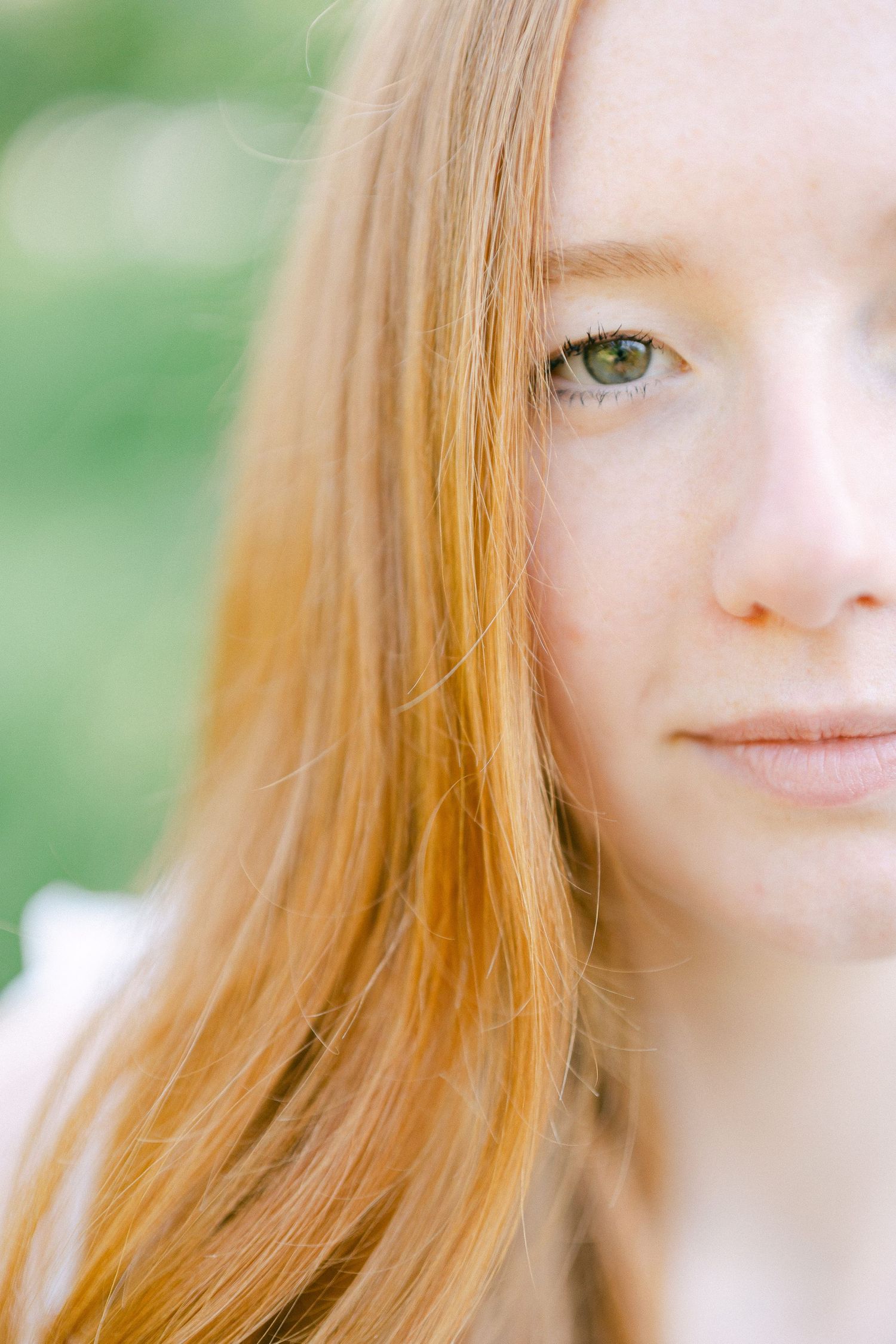 A series of close-up photos showing segments of a face with red hair against a soft green background.