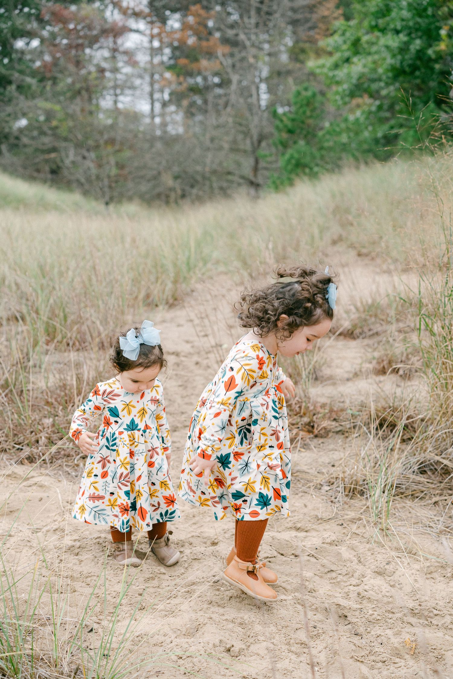 A sequence of photos showing a person wearing a colorful floral dress playing in sandy terrain among tall grass.