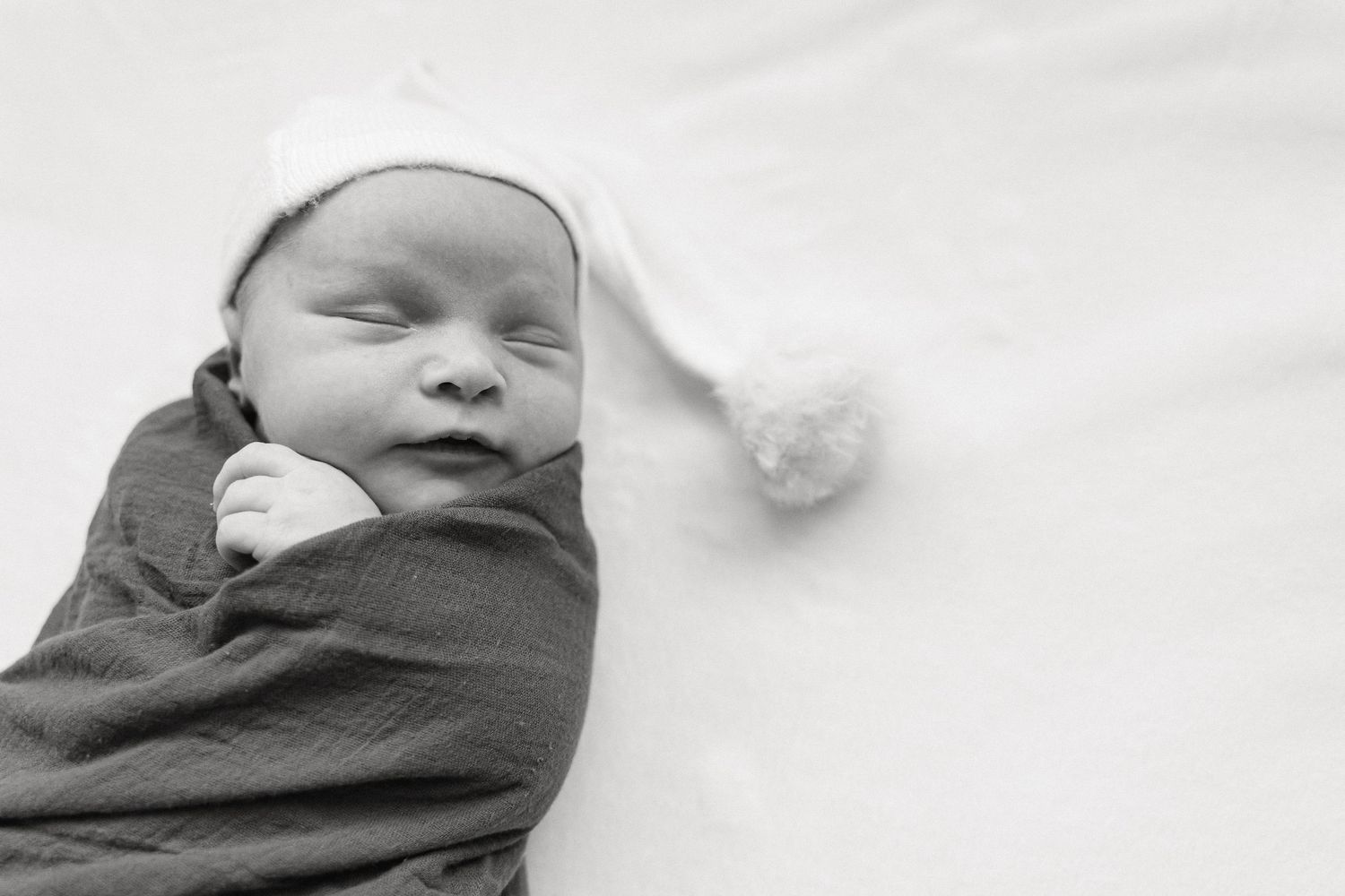 A series of black and white photographs showing a sleeping infant in different positions.