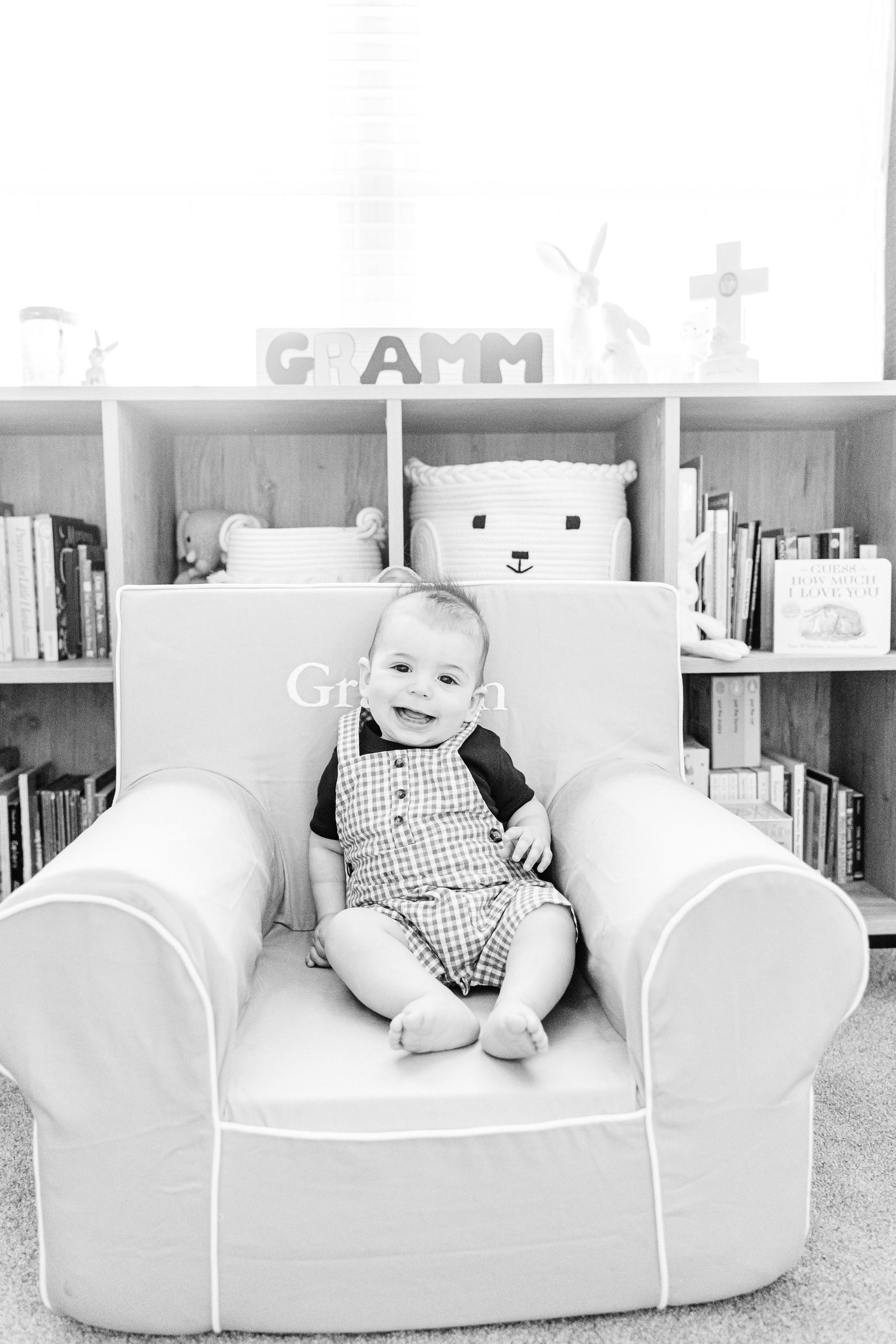 Series of black and white photos showing baby on white armchair with bookshelves in background.
