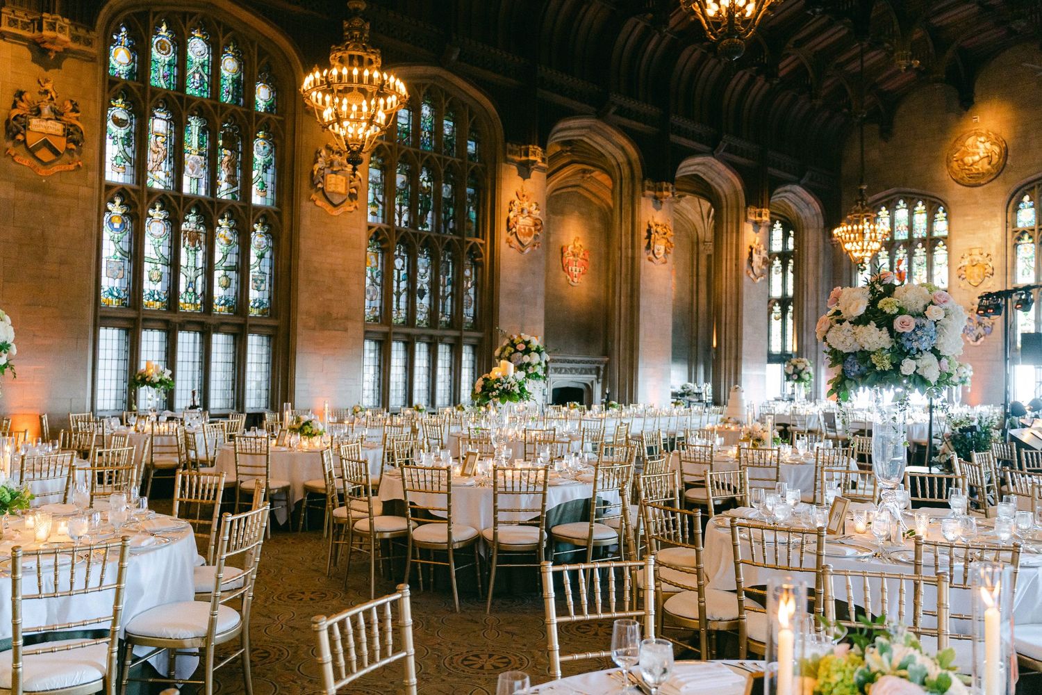 Elegant wedding reception in a grand hall with stained glass windows, and chandelier lighting in Chicago, IL