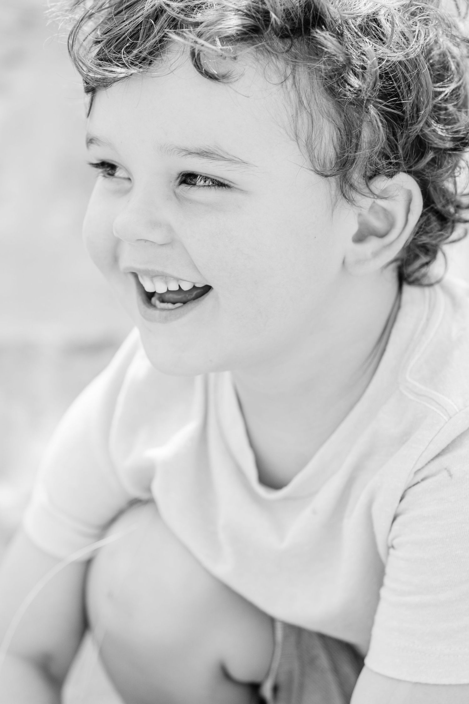 Black and white close-up portraits showing pure joy and laughter in a series of candid expressions.