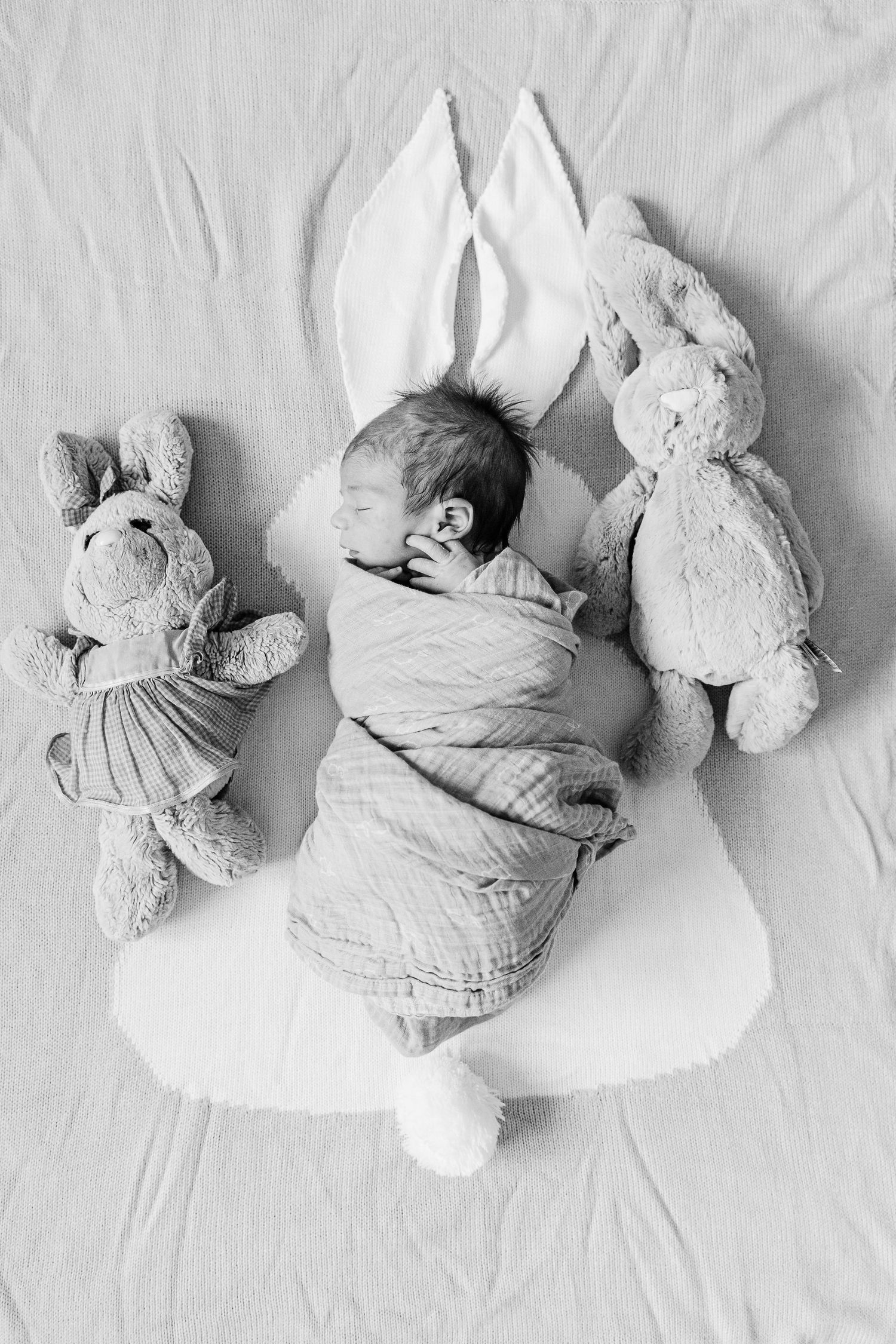 Series of high key photos showing a sleeping baby next to a plush bunny toy on white bedding.