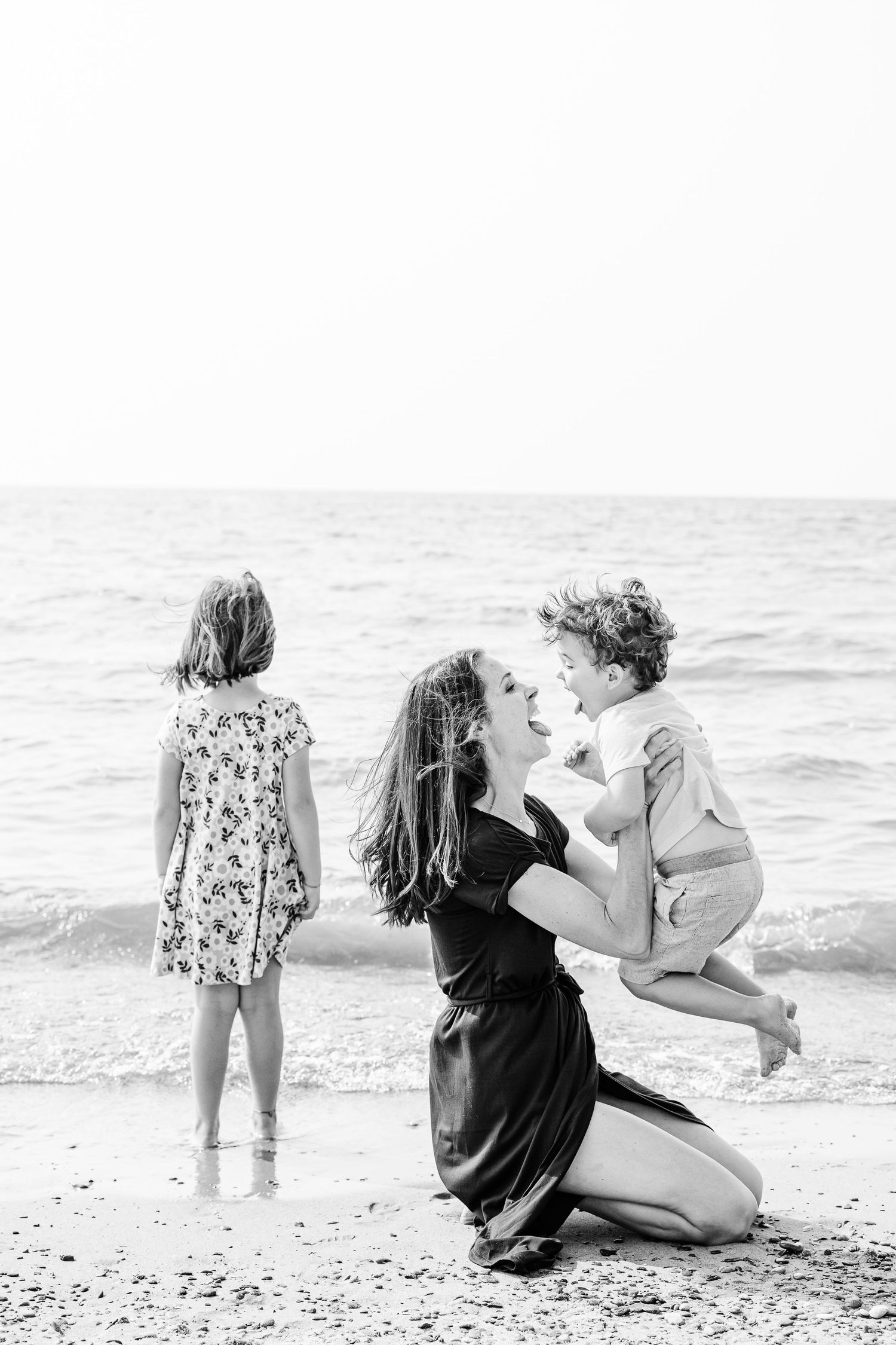 Black and white sequence of beach moments captured at the shoreline with waves in the background.