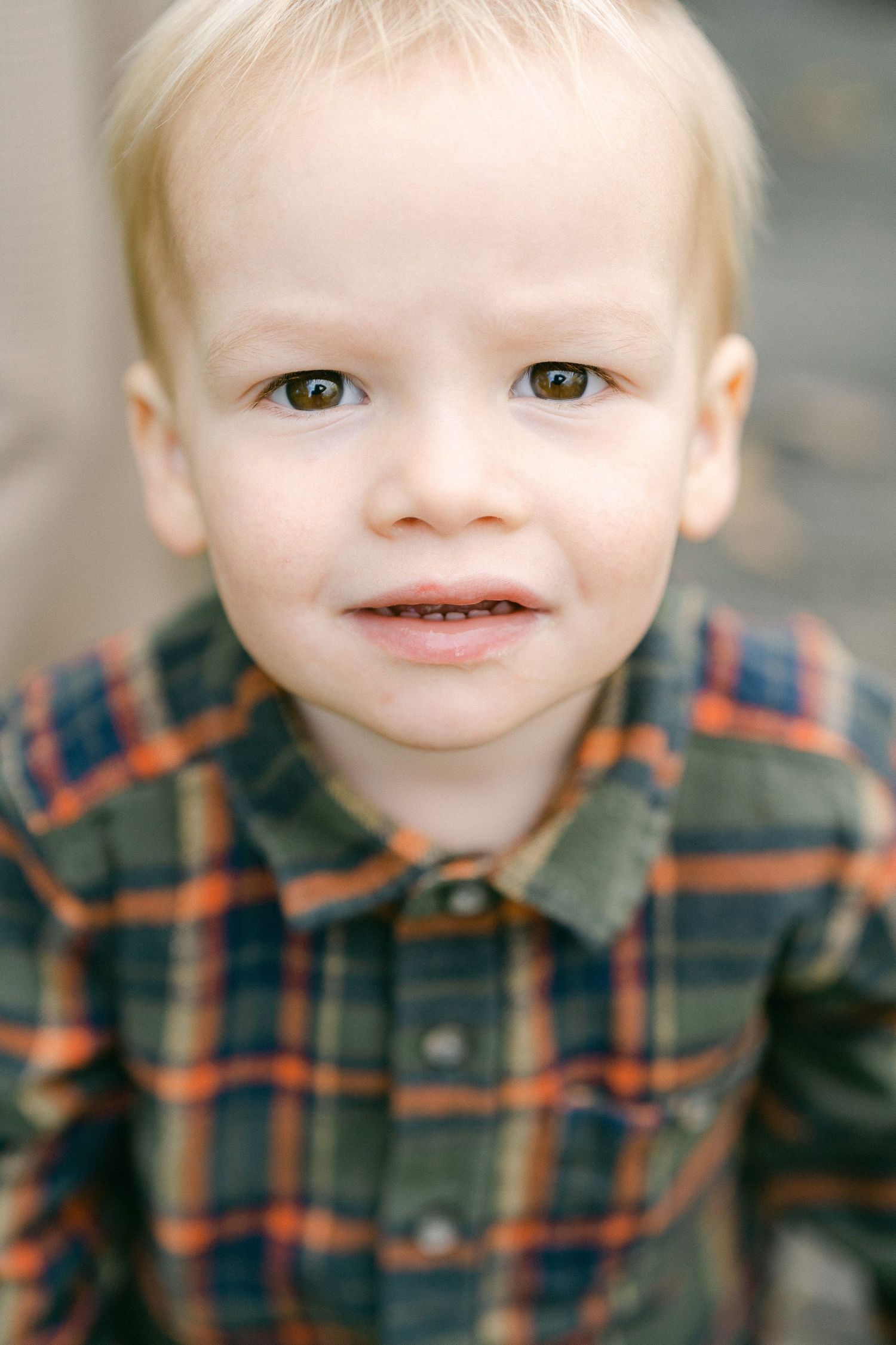 Close up series of young child wearing plaid flannel shirt showing different expressions.