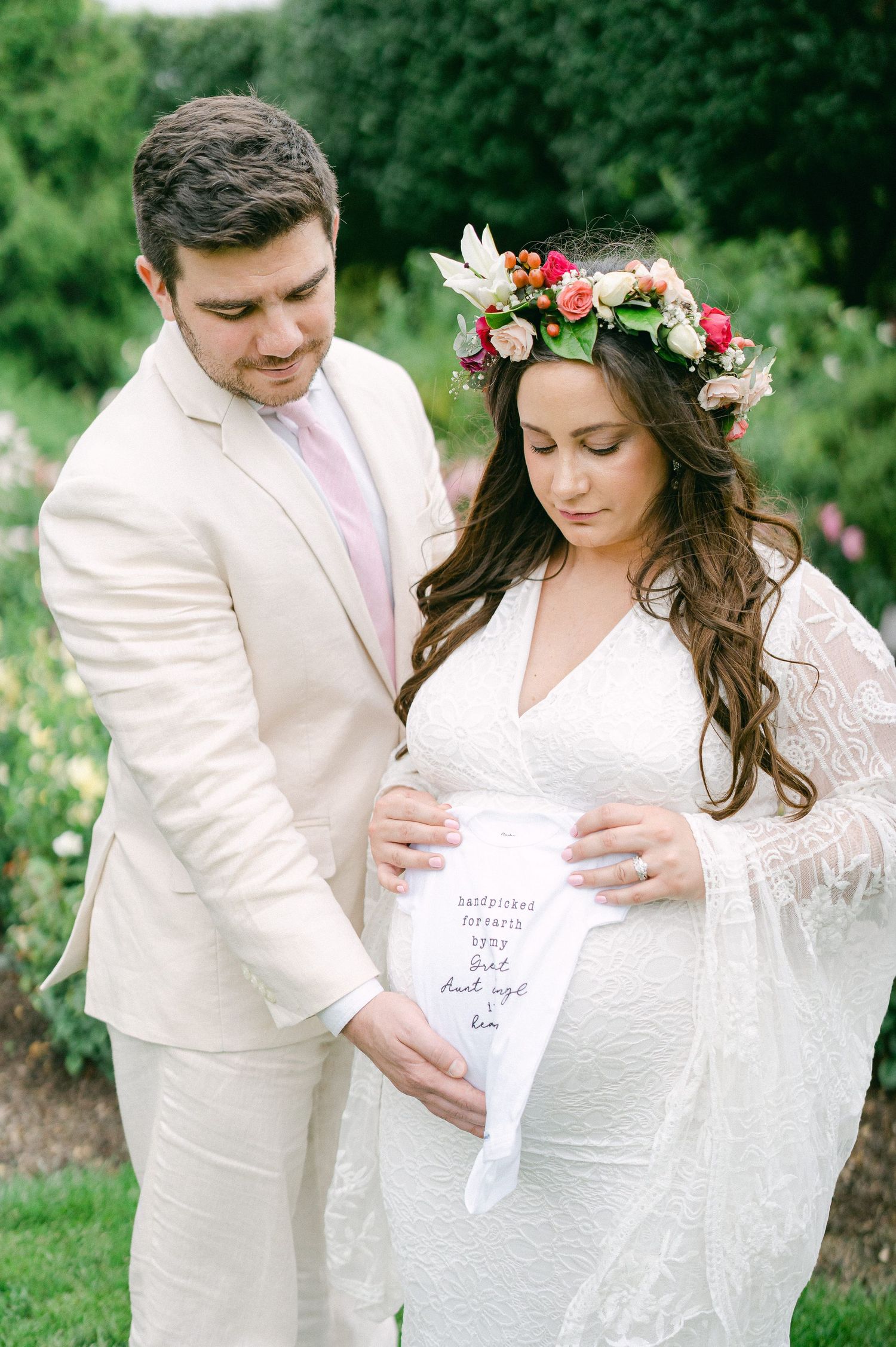 Wedding couple sharing intimate moments while holding handwritten notes in an outdoor garden setting.
