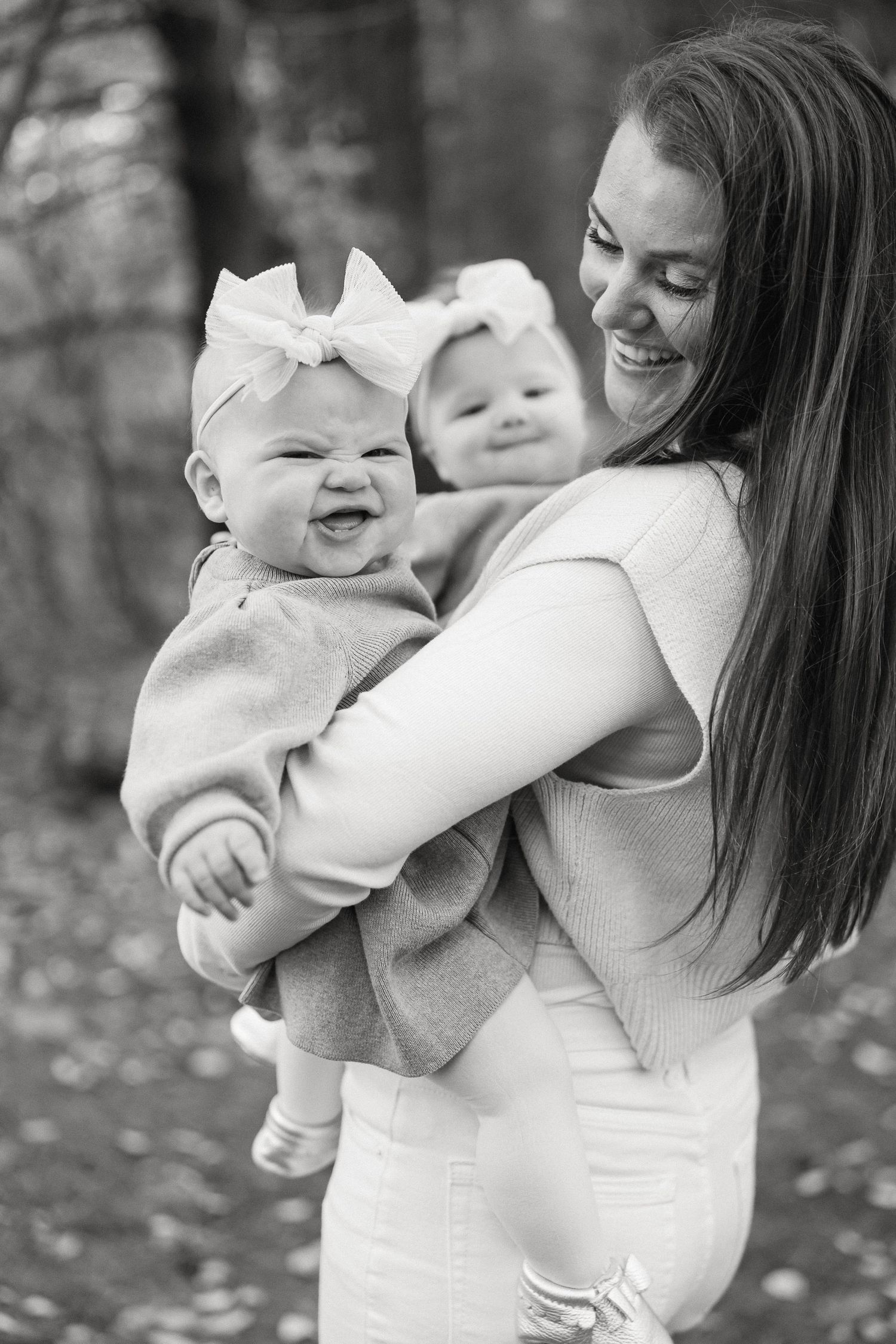 A joyful black and white photo series showing tender moments between parent and baby with a white bow.
