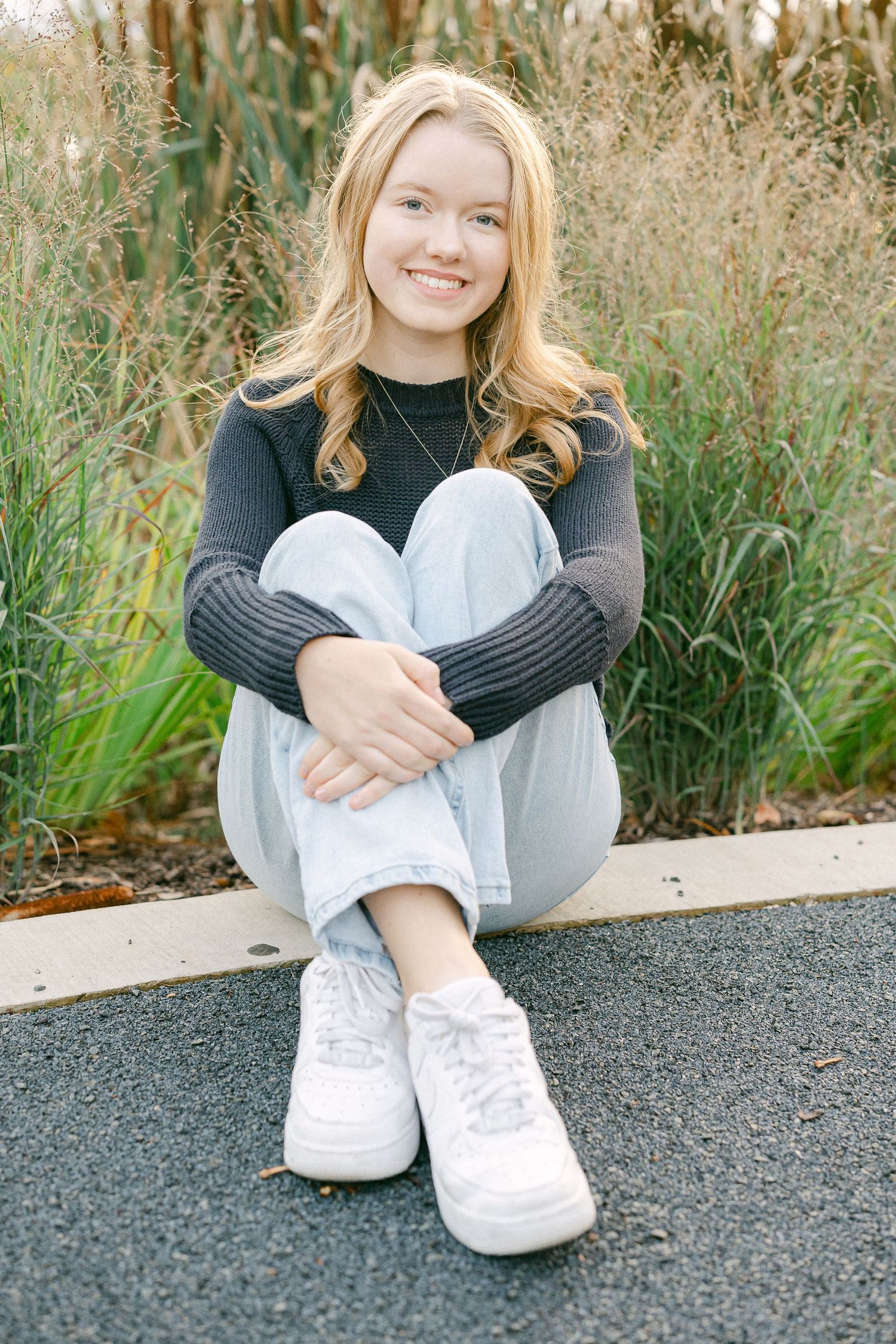 A series of casual outdoor portraits showing someone sitting on pavement wearing white sneakers and dark clothing.