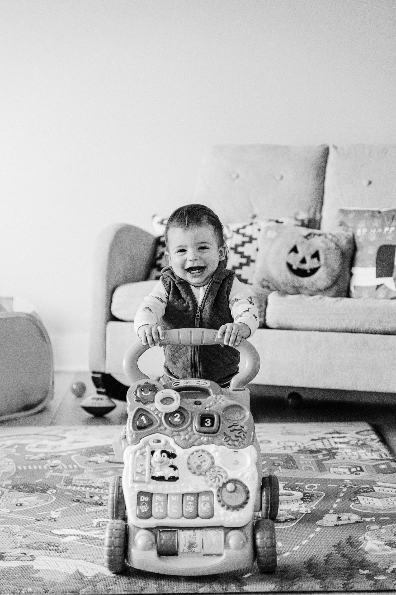 A black and white photo sequence showing a child playing with a toy car on a patterned rug.