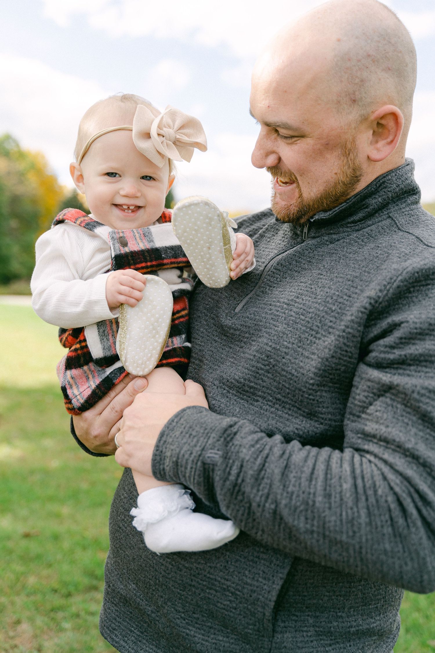A heartwarming sequence shows a father in a gray sweater playing and sharing joyful moments with a baby outdoors.