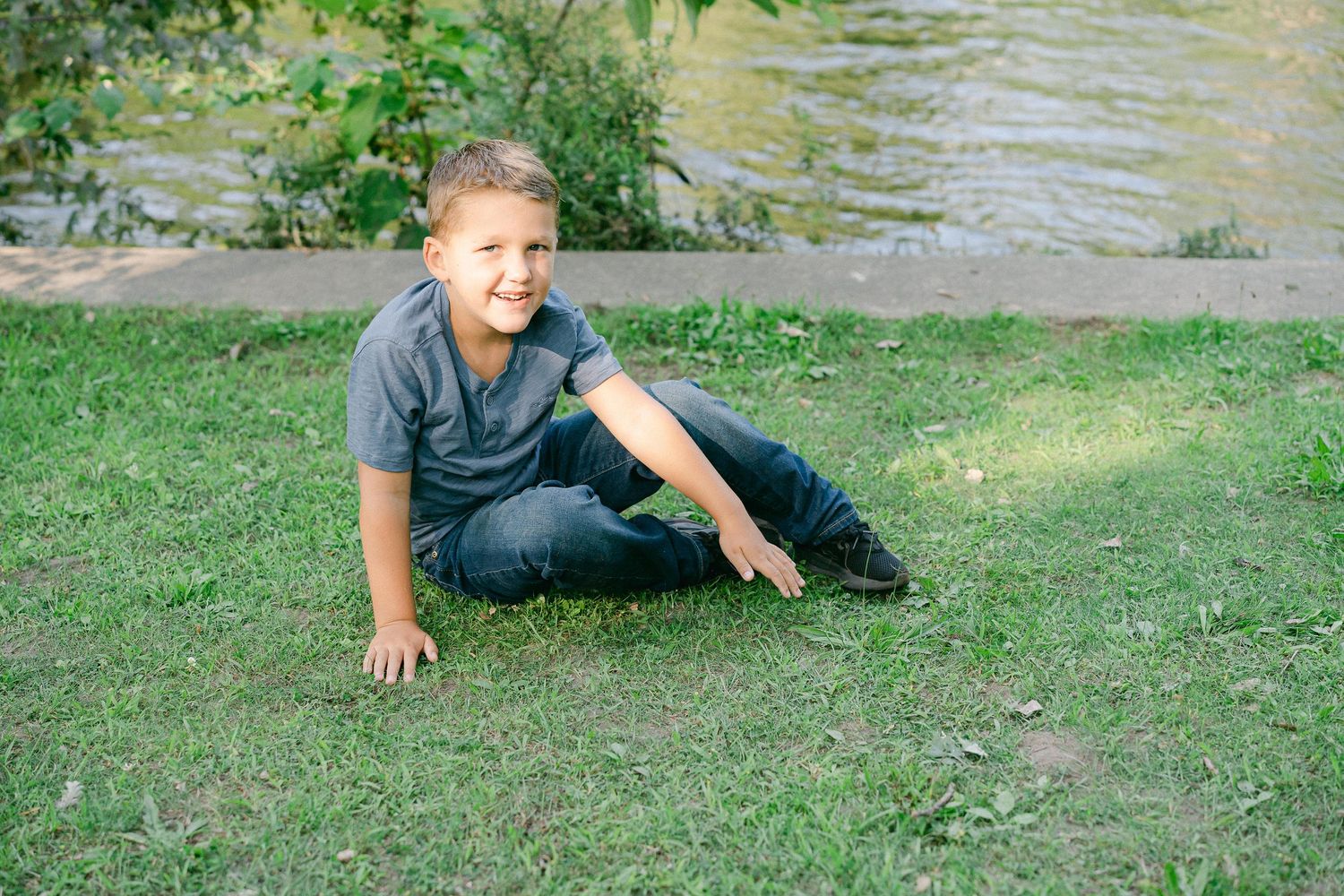 A sequence of photos shows someone rolling down a grassy hill in a playful manner on a sunny day.