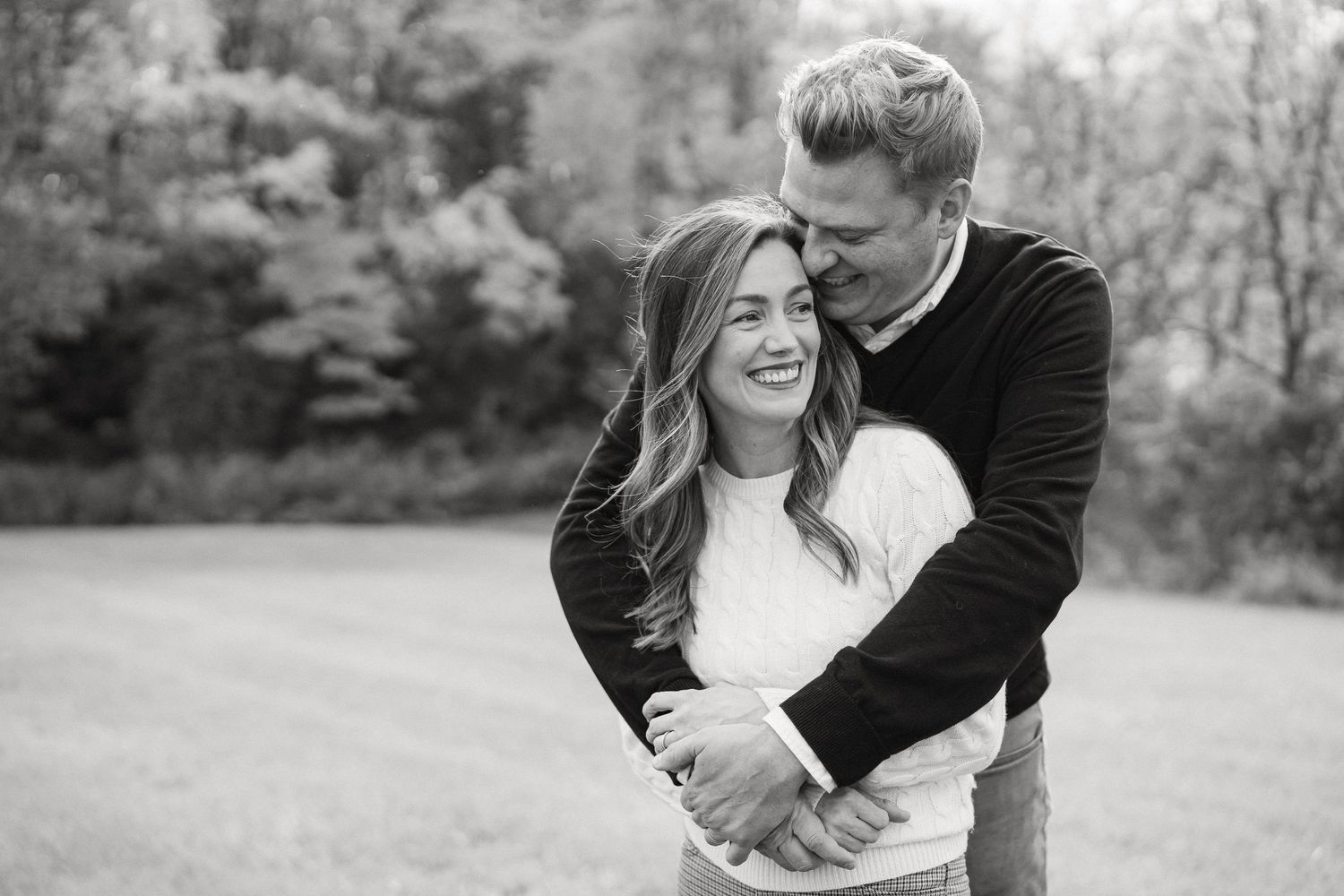 Candid black and white photos of people embracing and laughing together in an outdoor setting.