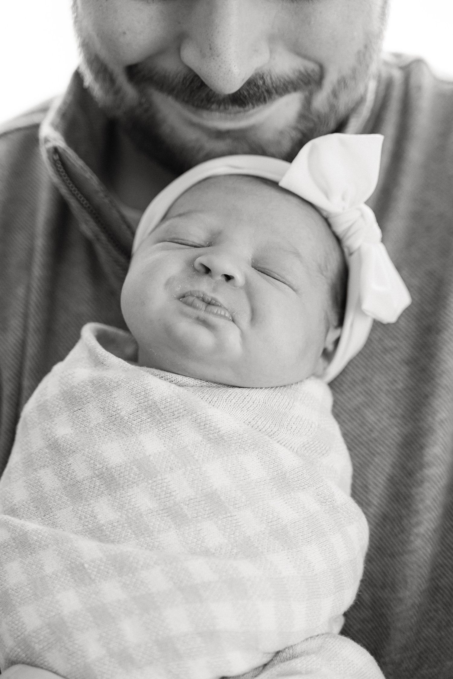 Black and white photo series showing a sleeping baby in a white blanket with close-up views from different angles.