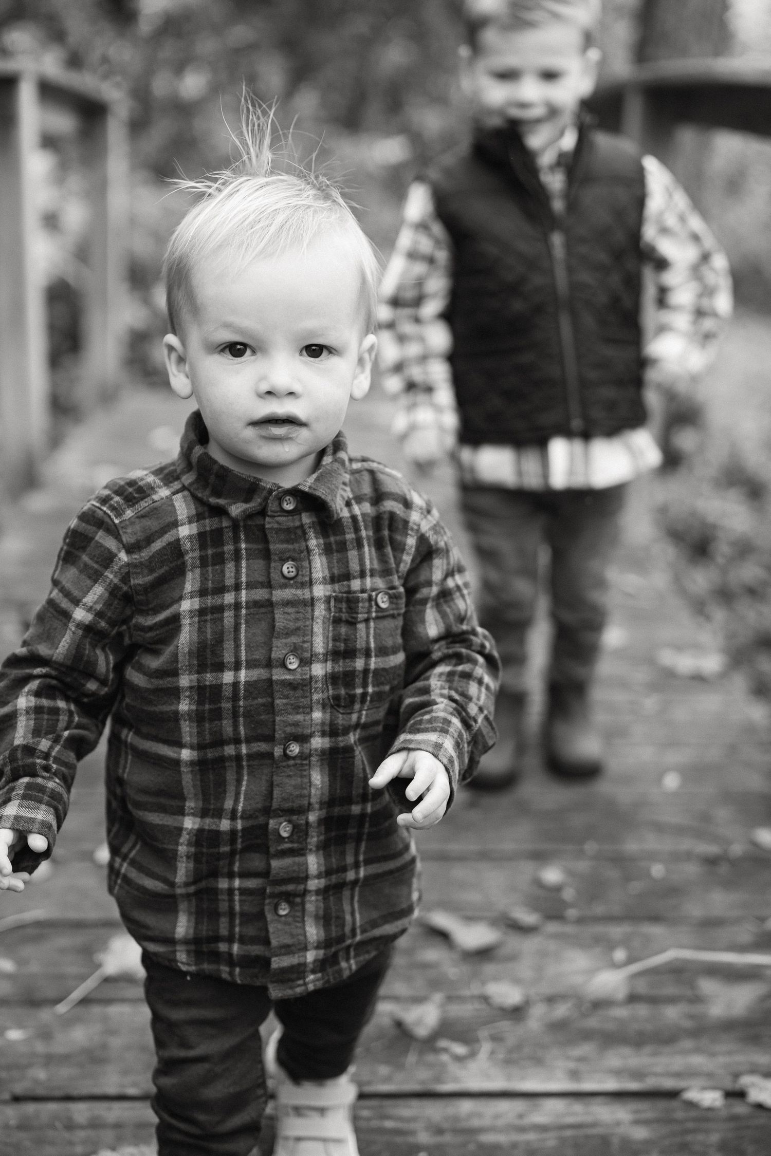 Black and white photo sequence shows toddler in plaid shirt walking outdoors during autumn.
