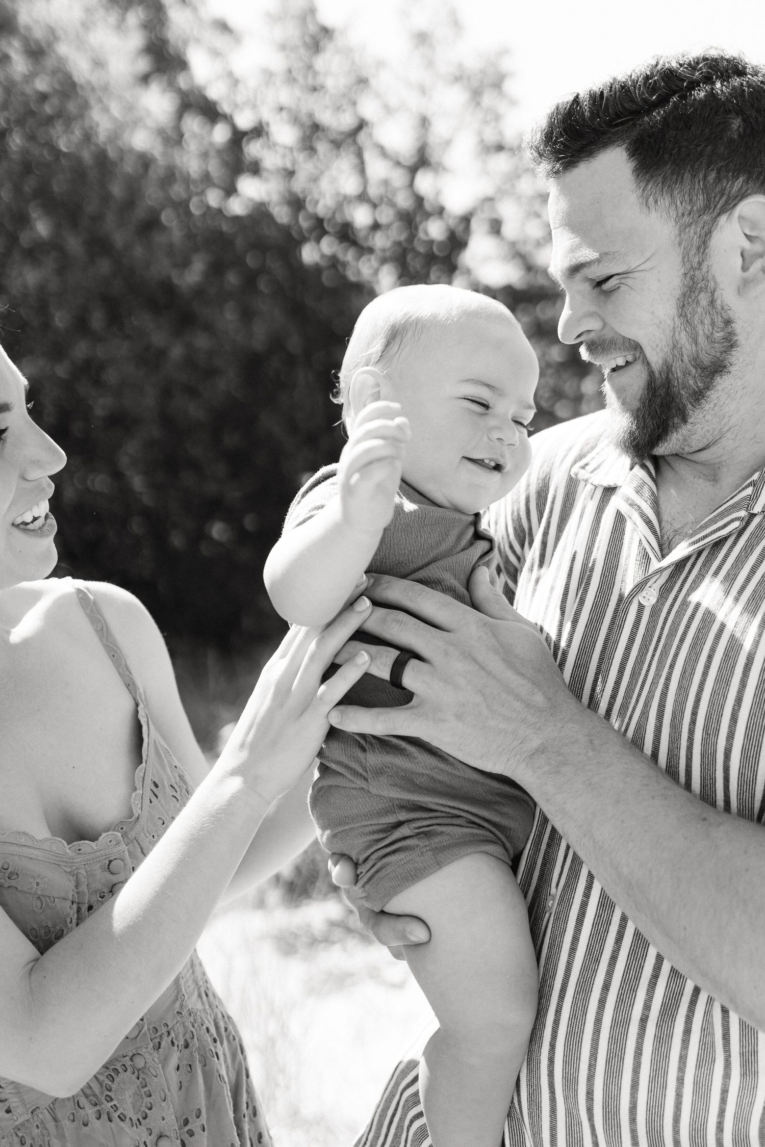 Black and white photo sequence showing tender moments of parent and baby bonding with joyful expressions.