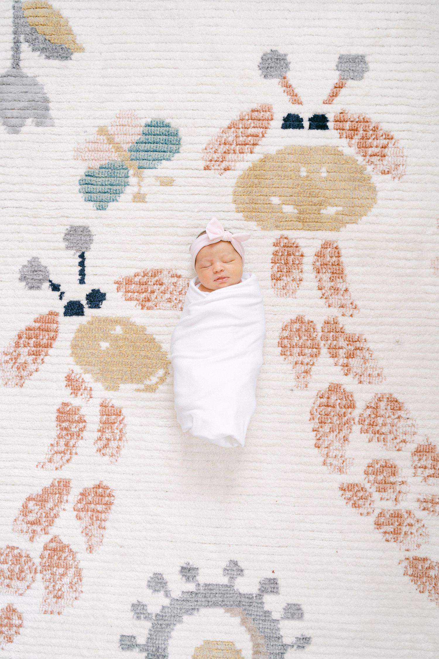 A floral pattern in soft peach, beige and gray tones decorates a light colored textured background.