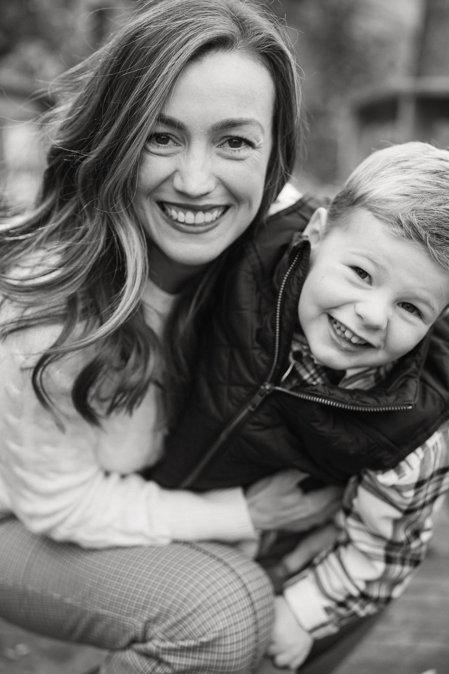 A series of black and white candid portraits showing joyful expressions and genuine laughter.