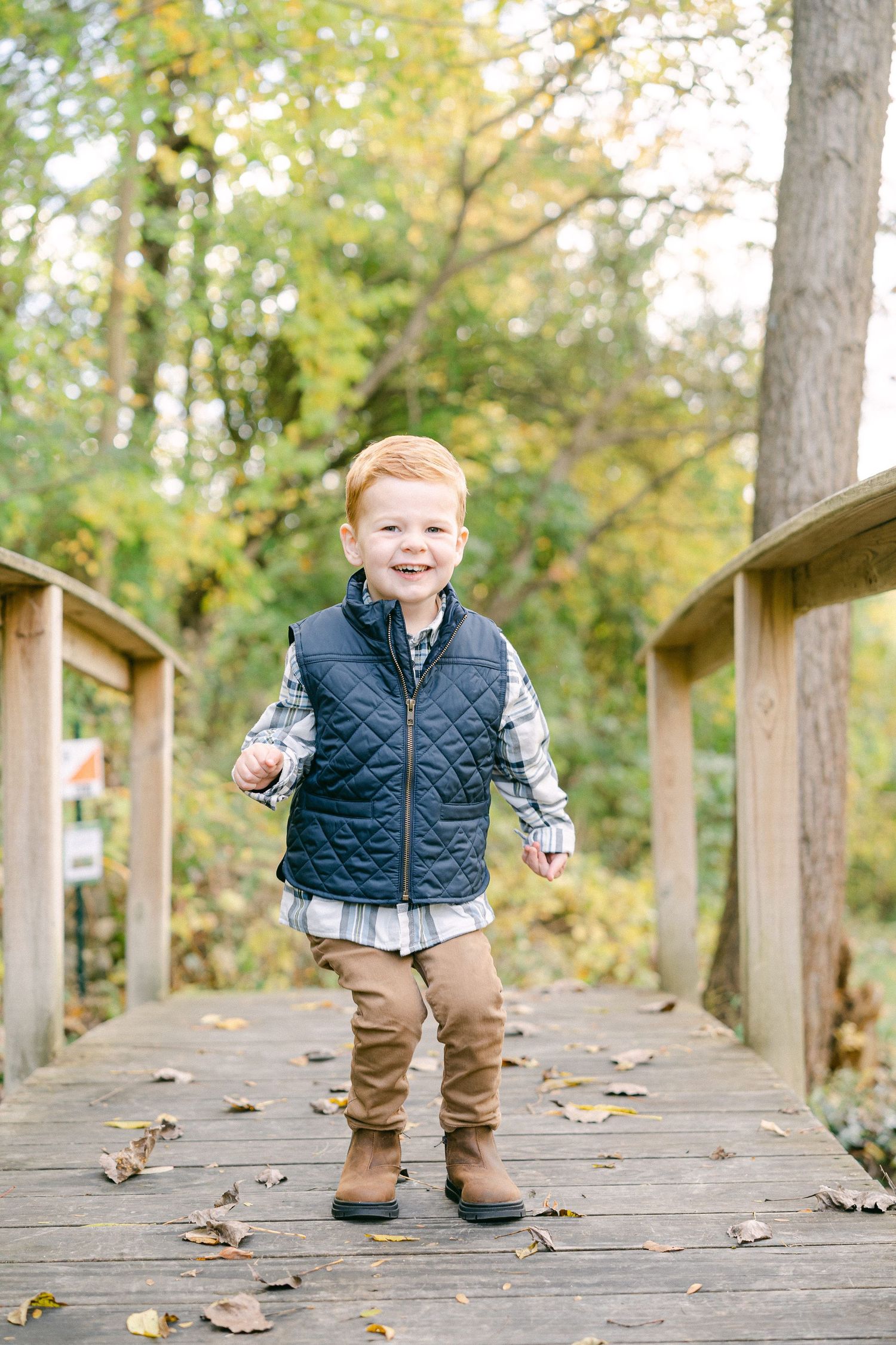 A series of playful moments captured on a wooden boardwalk surrounded by autumn trees.
