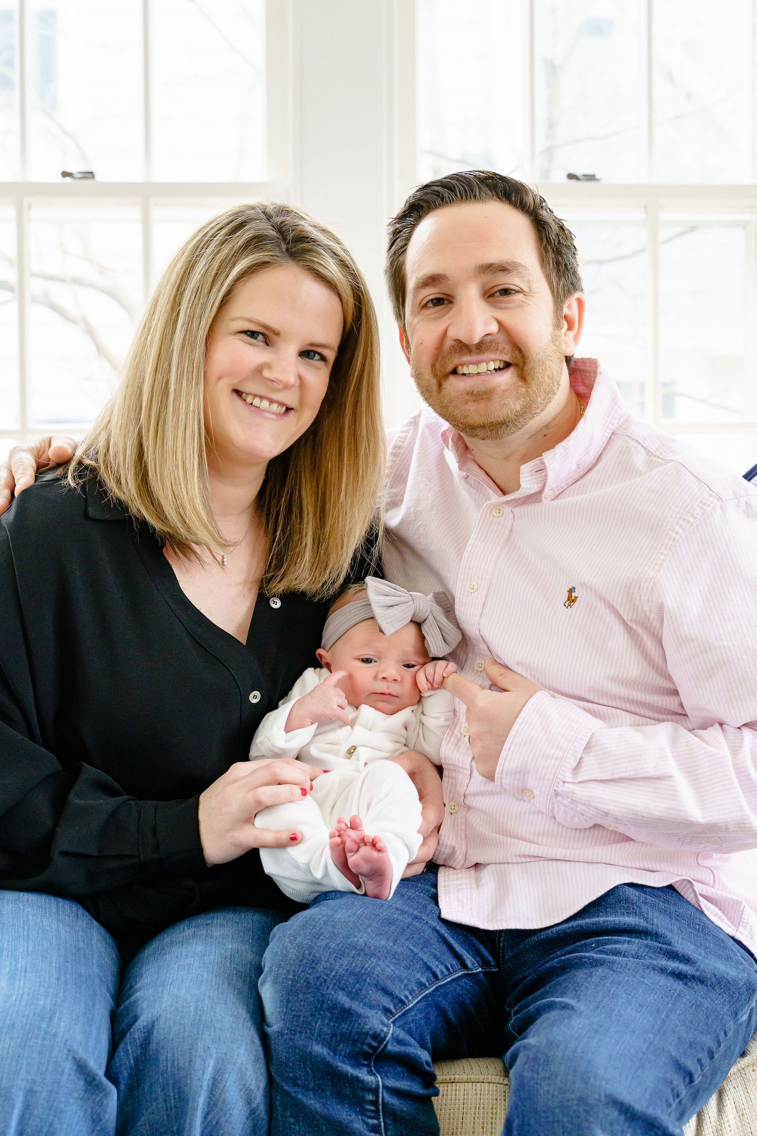 Family portrait series showing parents with their baby in casual attire against a bright interior background.