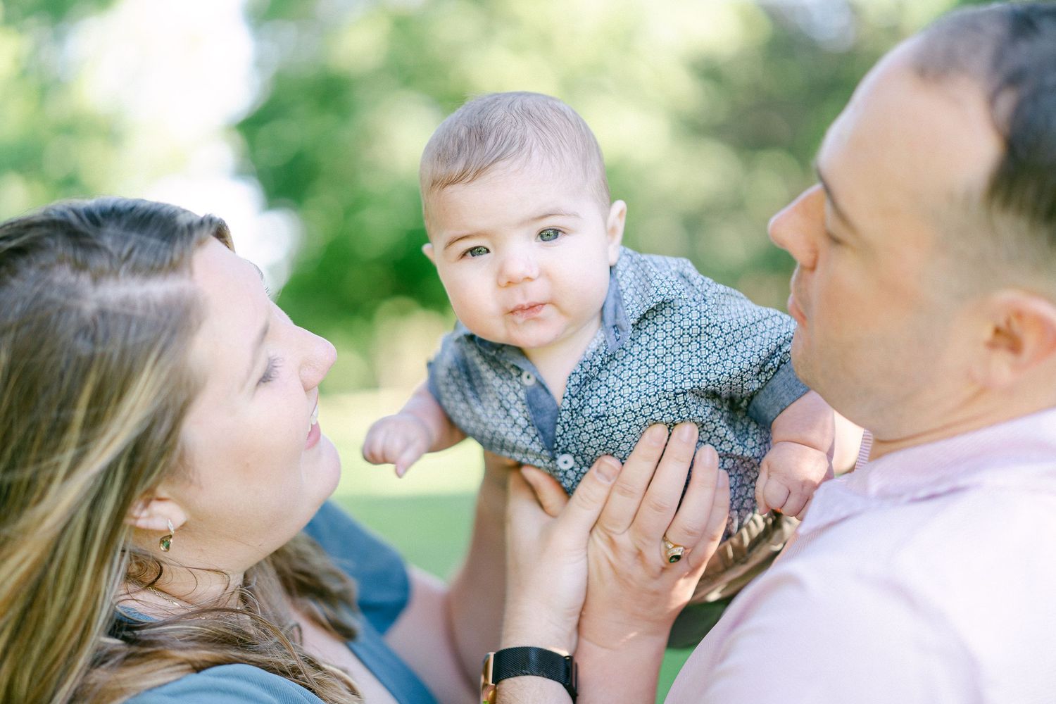 Sweet candid moments shared between family members in a bright outdoor setting.
