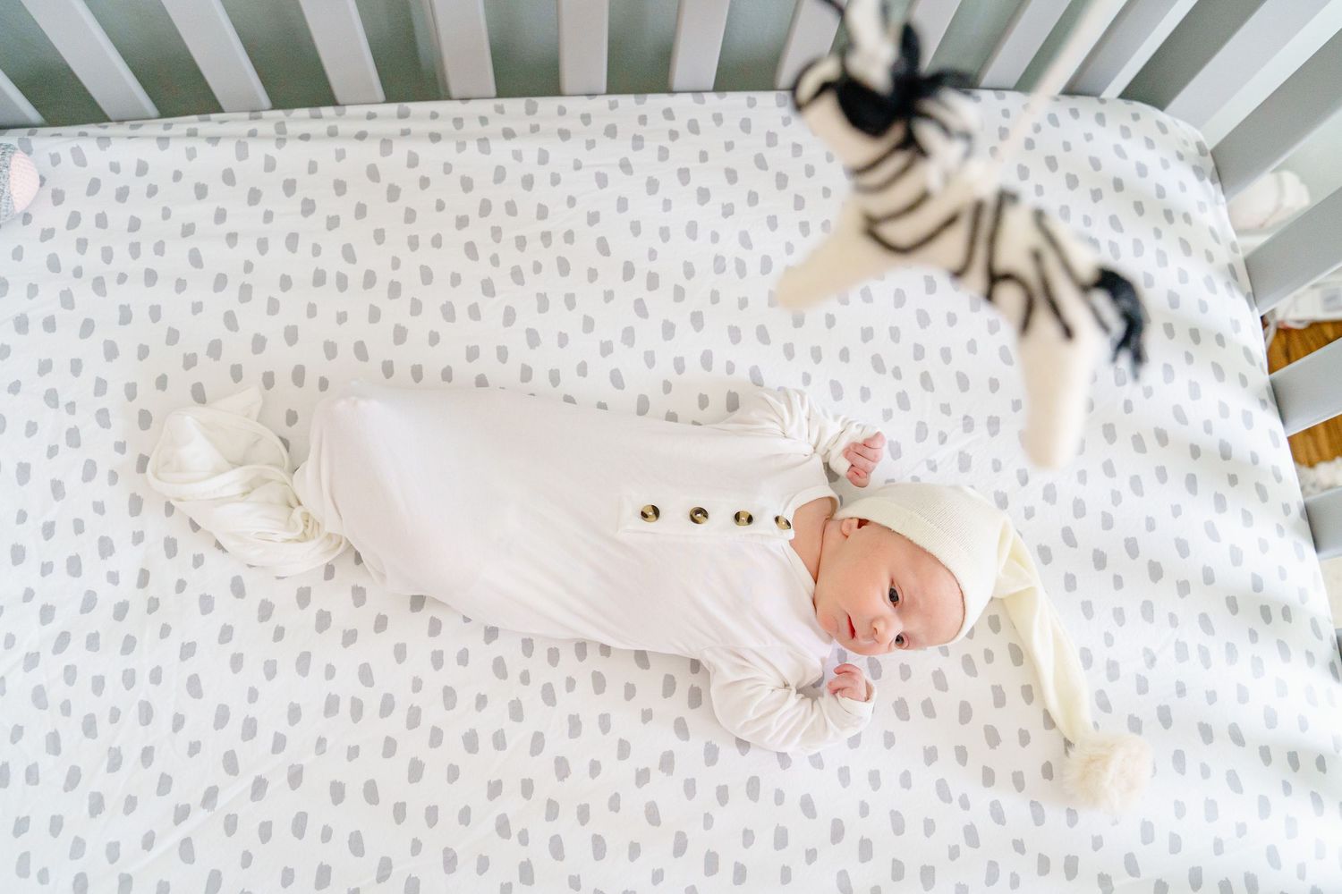A series of newborn baby photos showing tiny feet and hands against a white textured background.