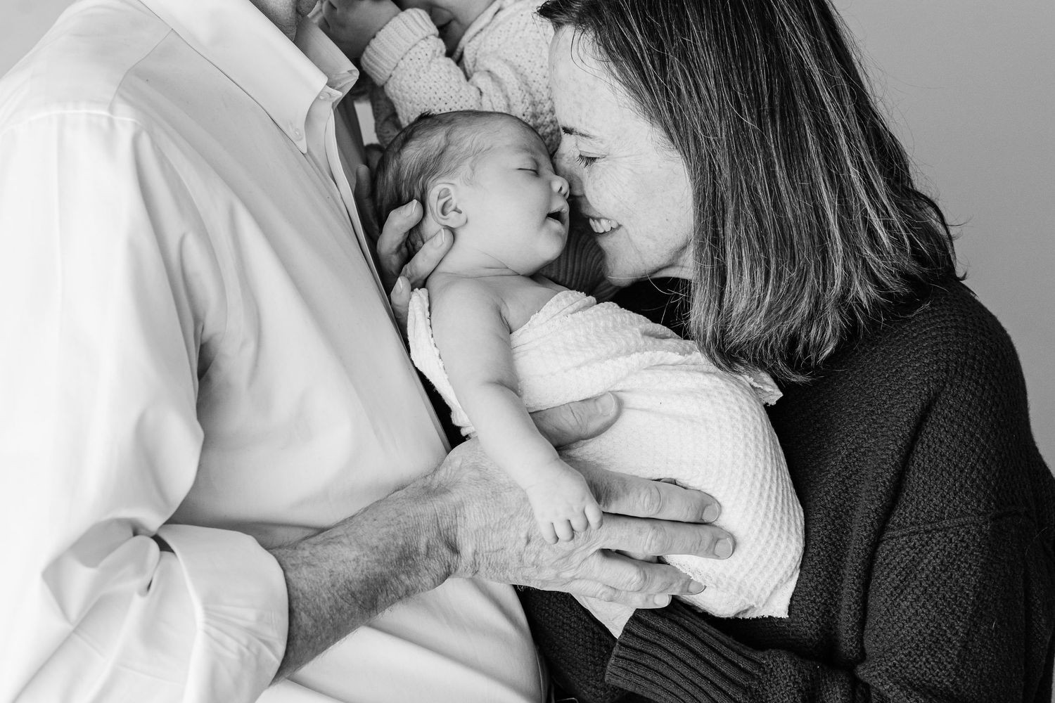 A series of intimate black and white photos showing tender moments between parent and child.
