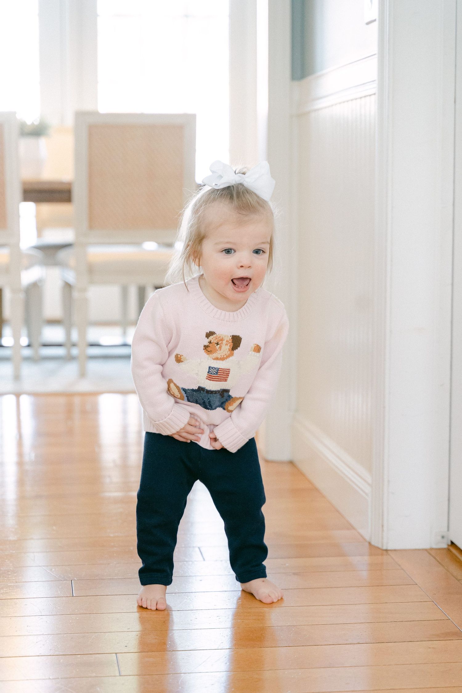 Bright white hallway with hardwood floors and sunlight creating a warm, welcoming atmosphere.