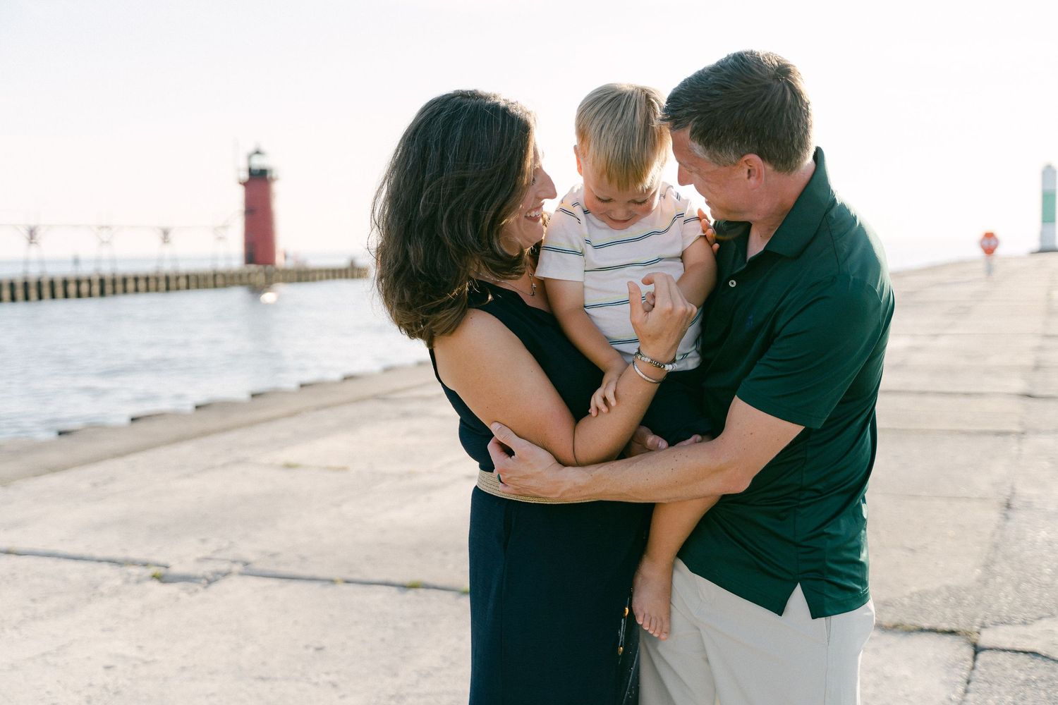 A couple embraces and shares an intimate moment together on a pier during sunset.