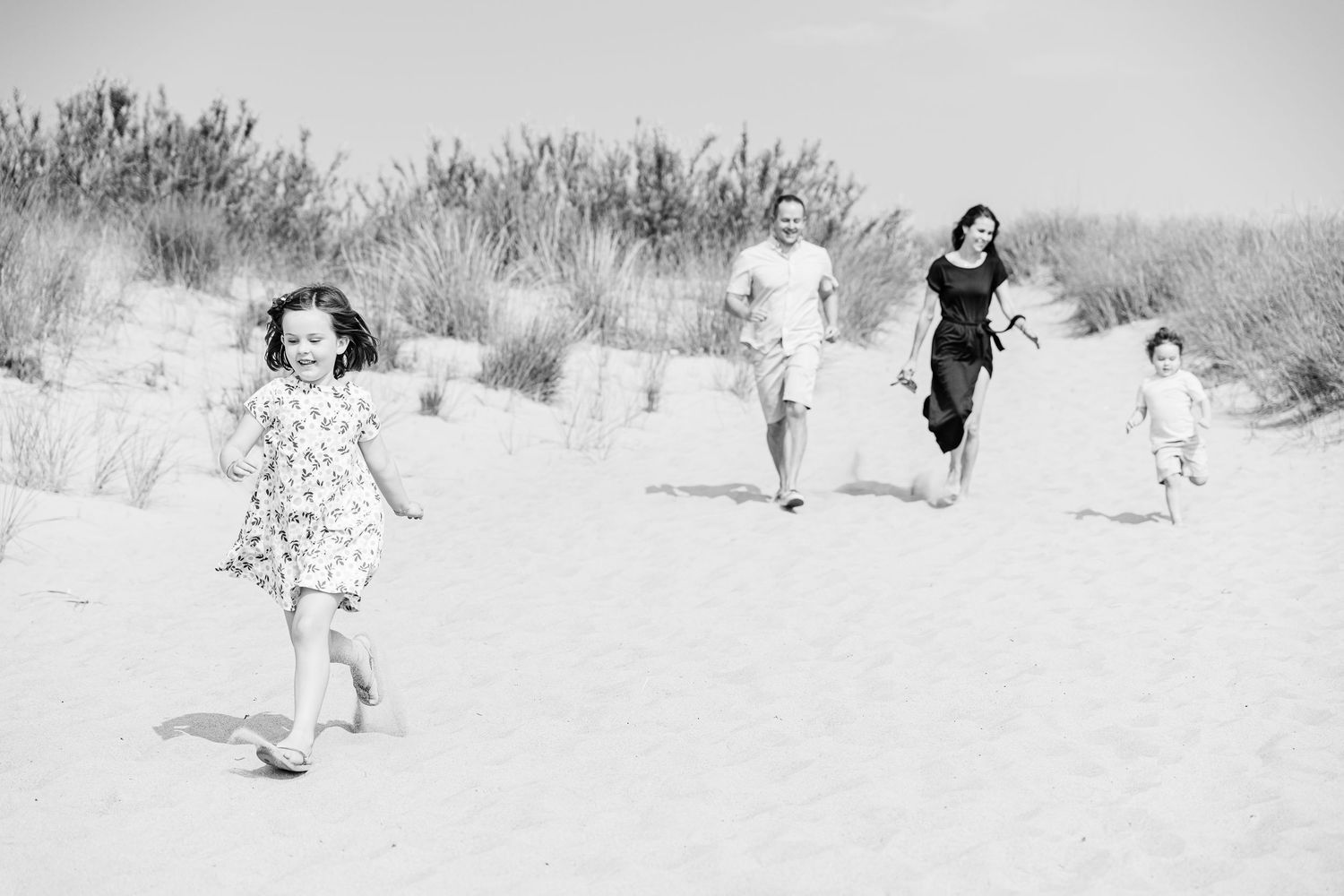 A black and white photo sequence shows a person dancing and twirling on a beach with graceful movements.