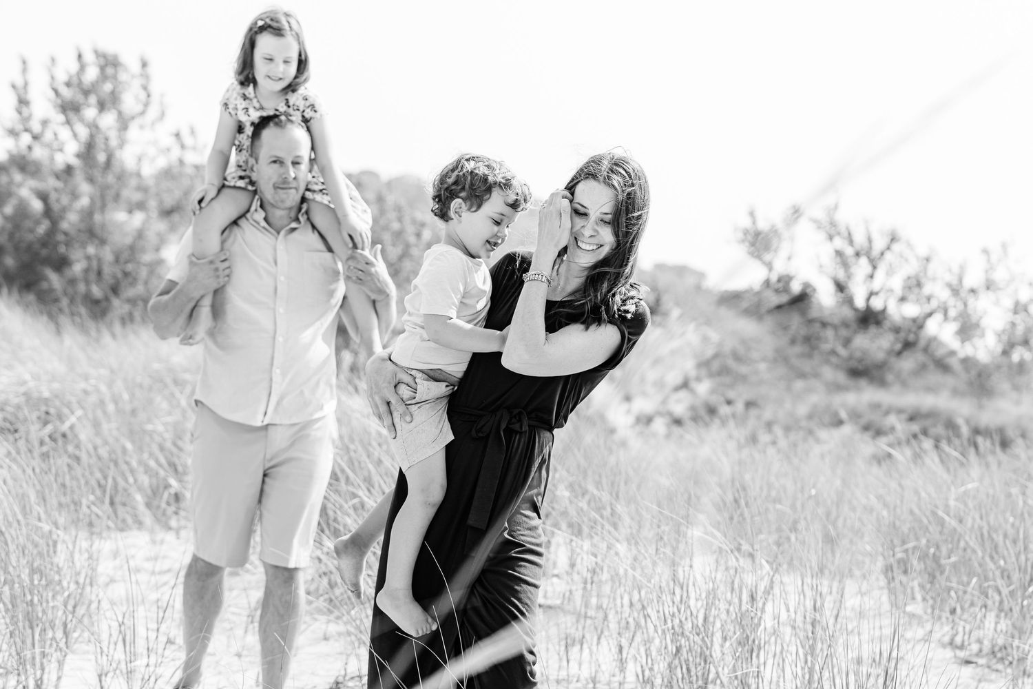 A couple embraces lovingly in a sun-drenched meadow during a romantic outdoor photo session.
