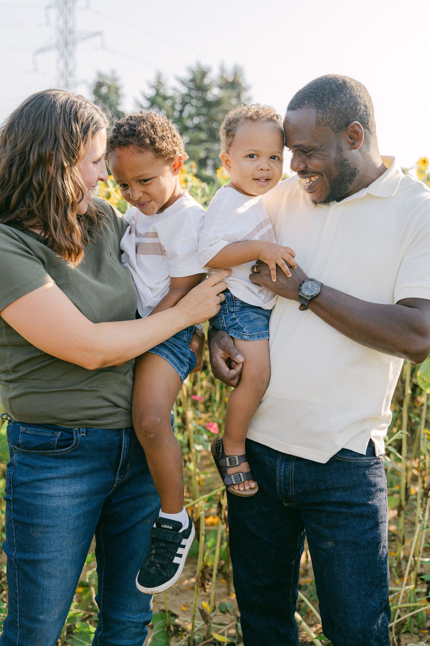 A loving family shares joyful moments together outdoors on a sunny day in a natural setting.