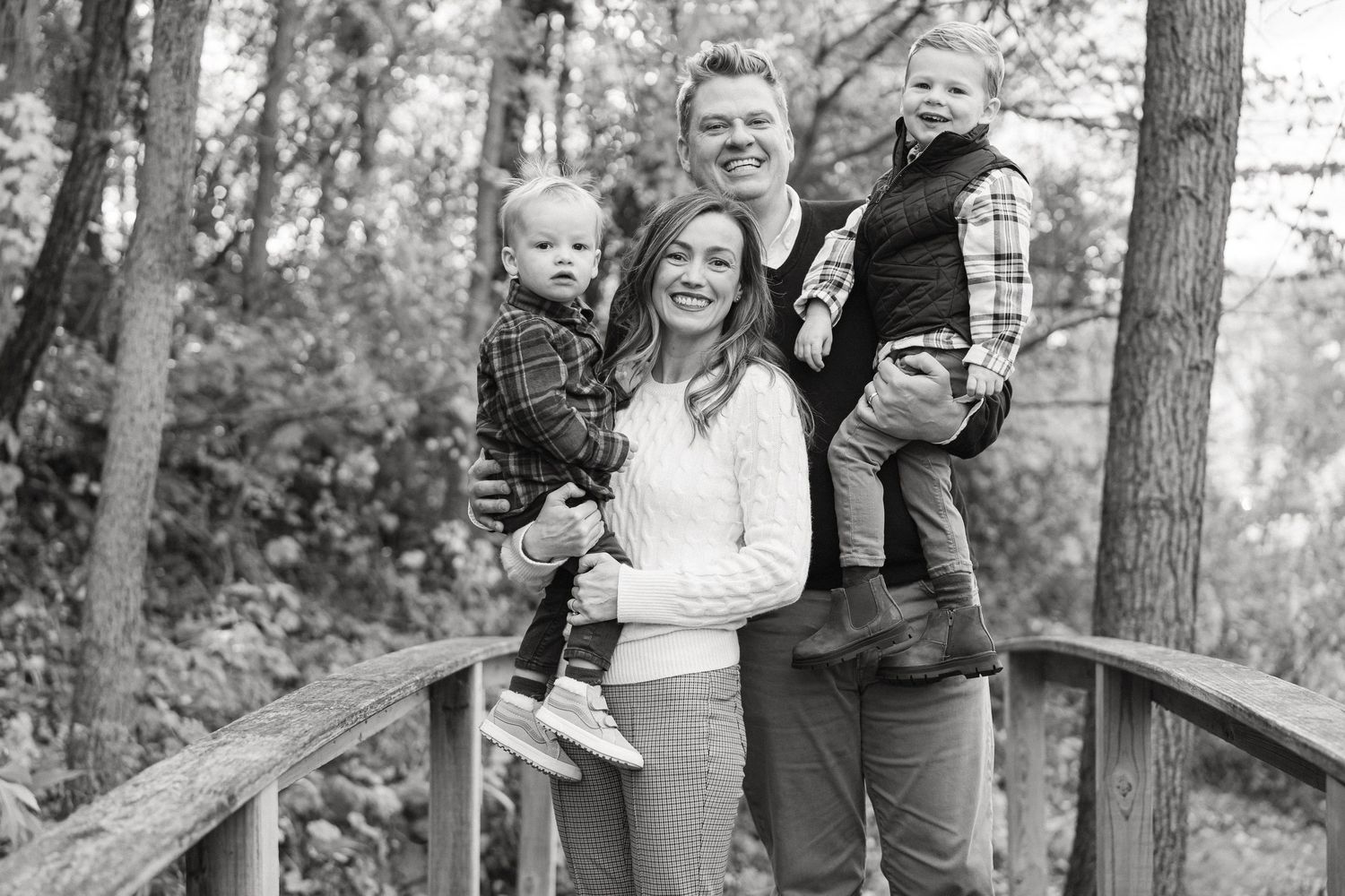 Family portrait series taken on wooden bridge in wooded autumn setting.