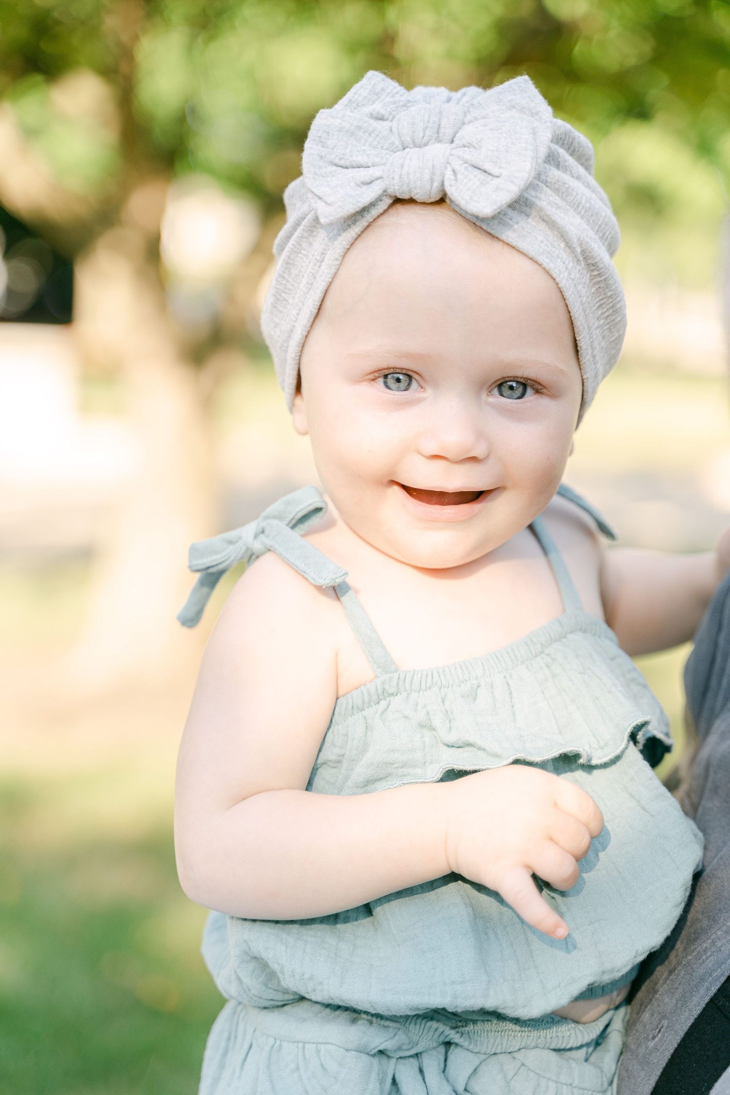 Series of close-up shots showing a baby in a mint green outfit with a matching bow headband.