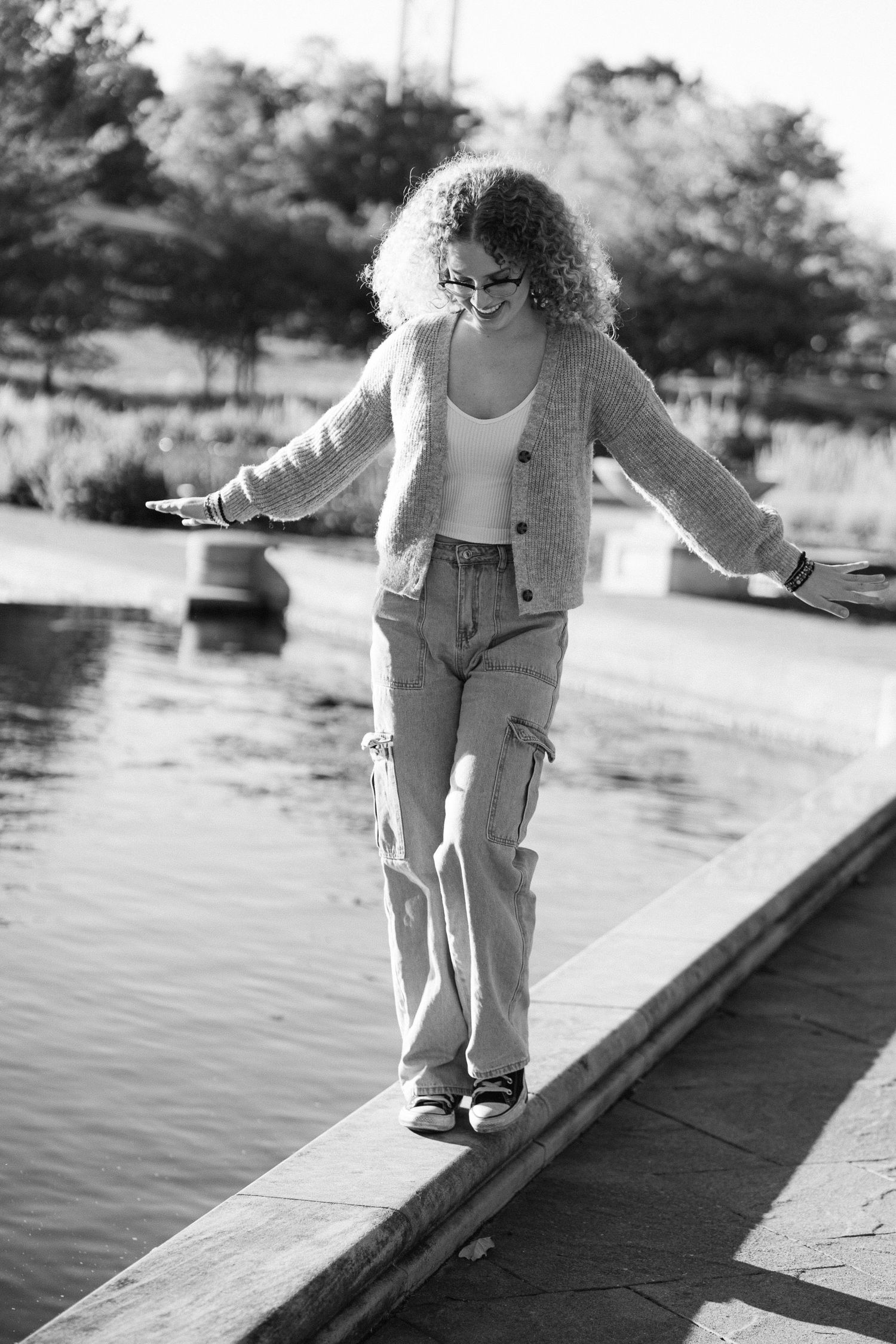 A toddler carefully walks along a wooden dock over water in a series of black and white photographs.