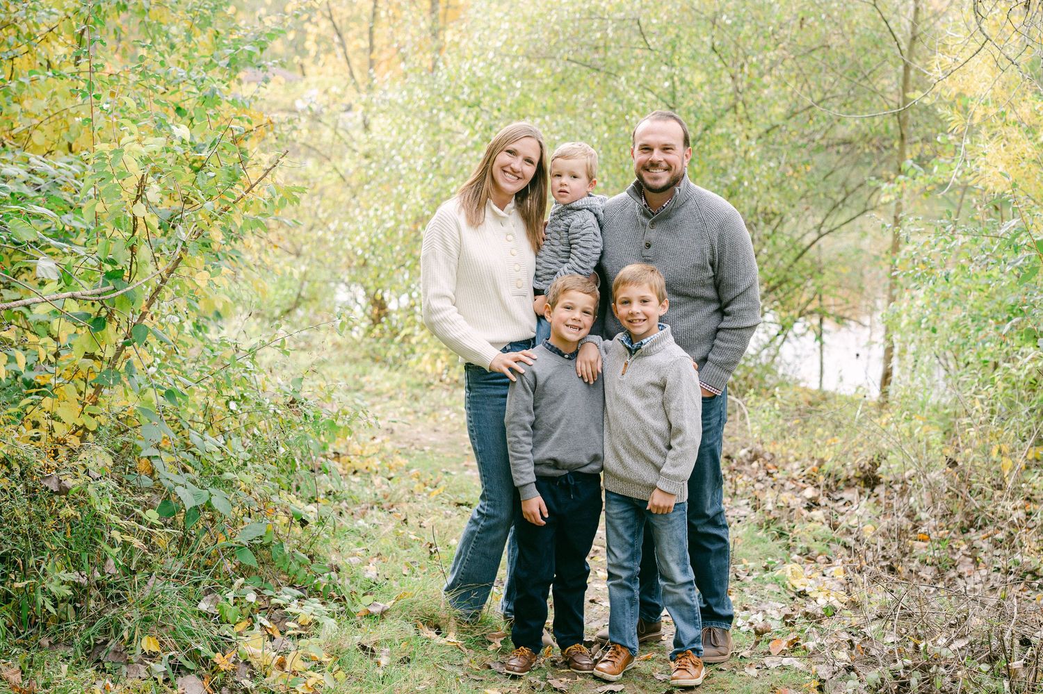 A group of people enjoying a sunny autumn day together in a wooded outdoor setting.