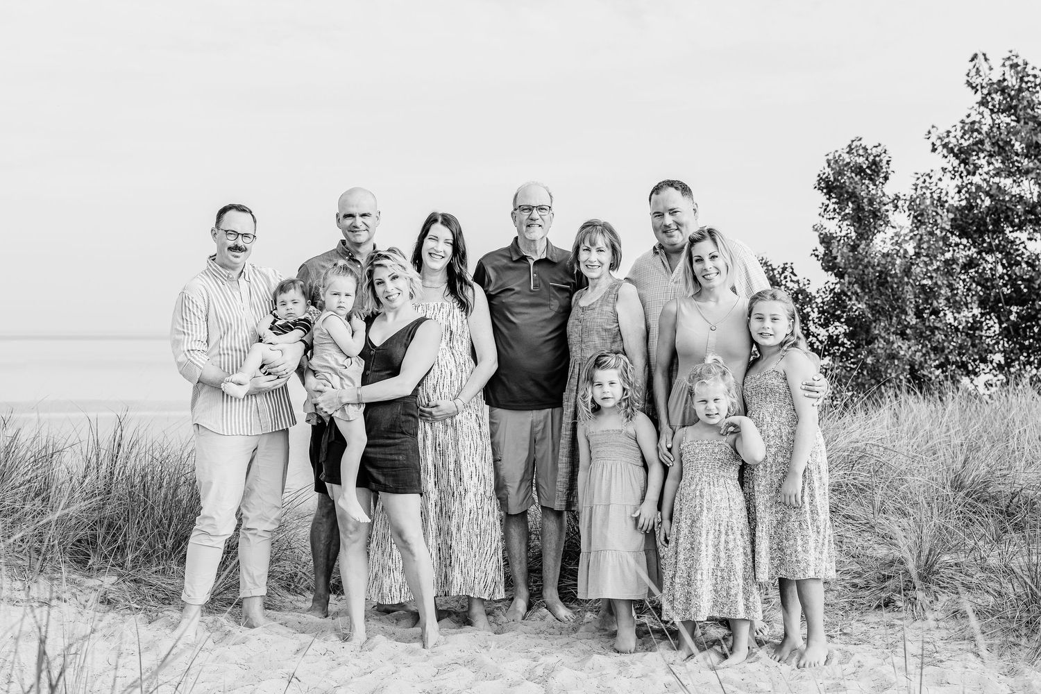 A black and white photo collage showing multiple group portraits taken outdoors in a natural setting.