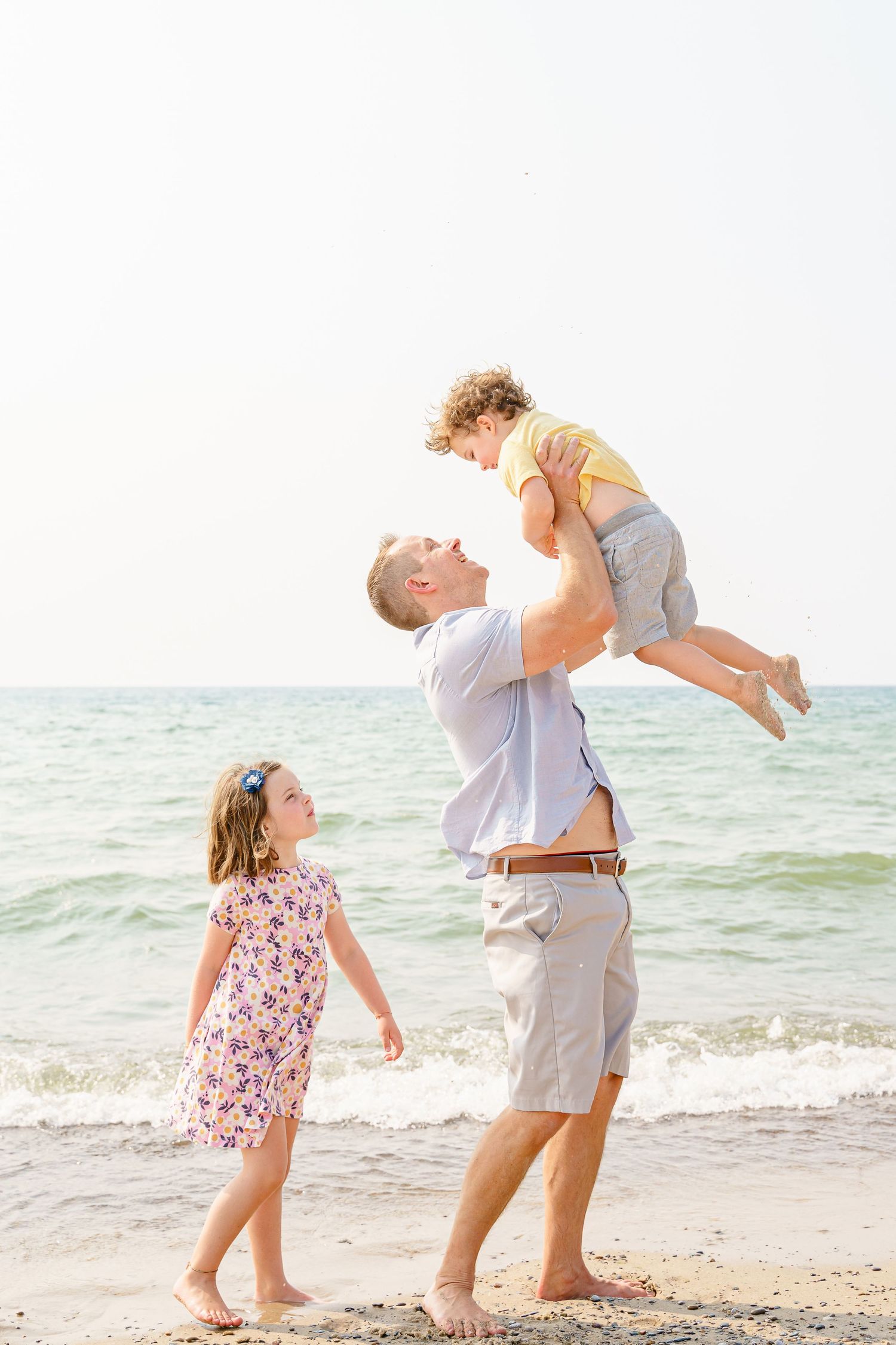 Playful moments captured on a bright beach as people enjoy the ocean waves.