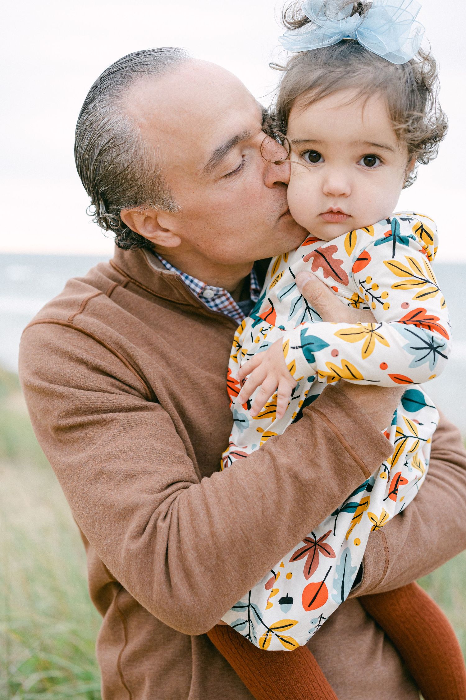 A series of tender moments captured between a person in a brown sweater and a small child wearing a patterned outfit.