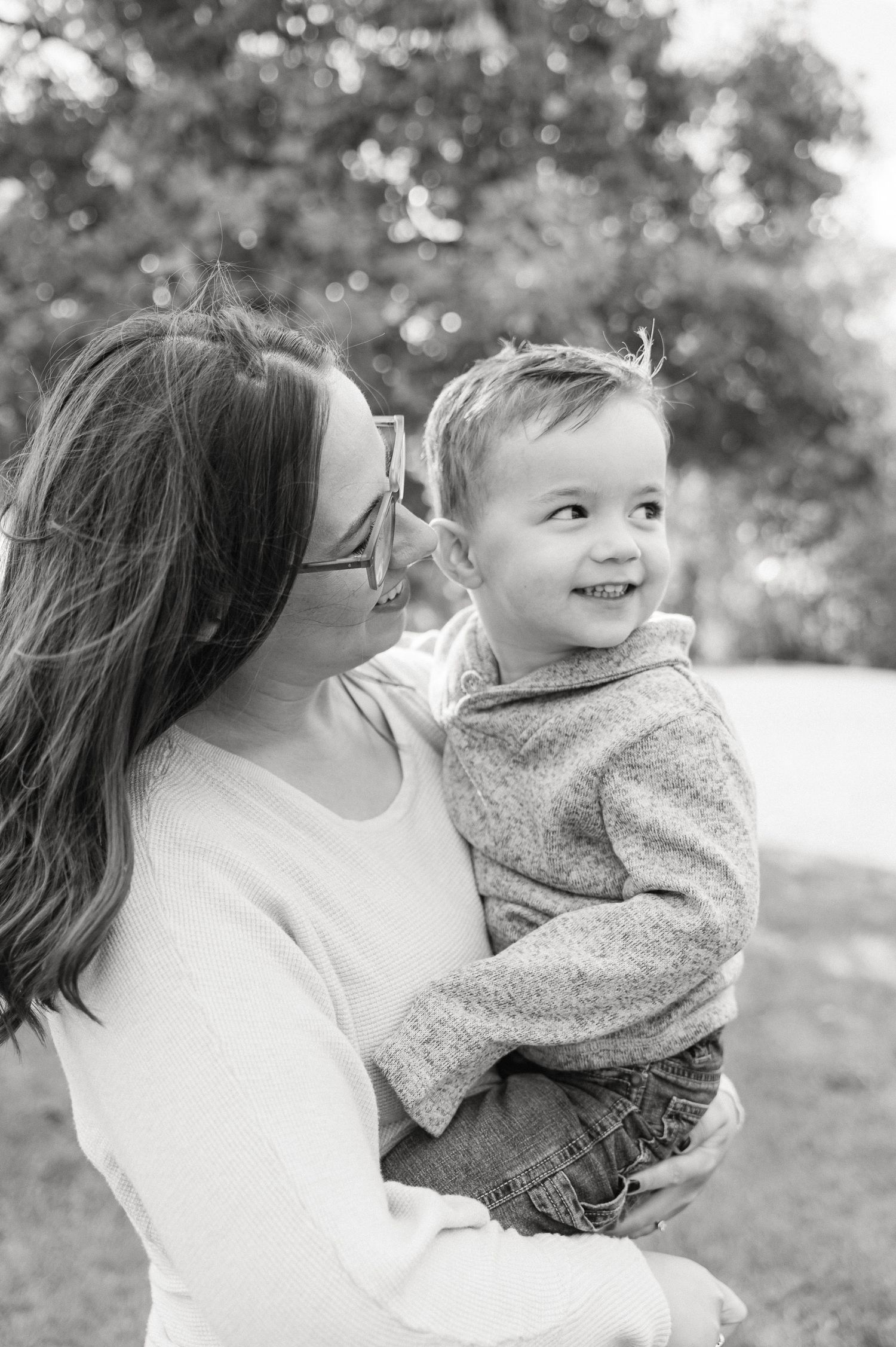 Black and white candid shots of joyful moments between parent and child outdoors.