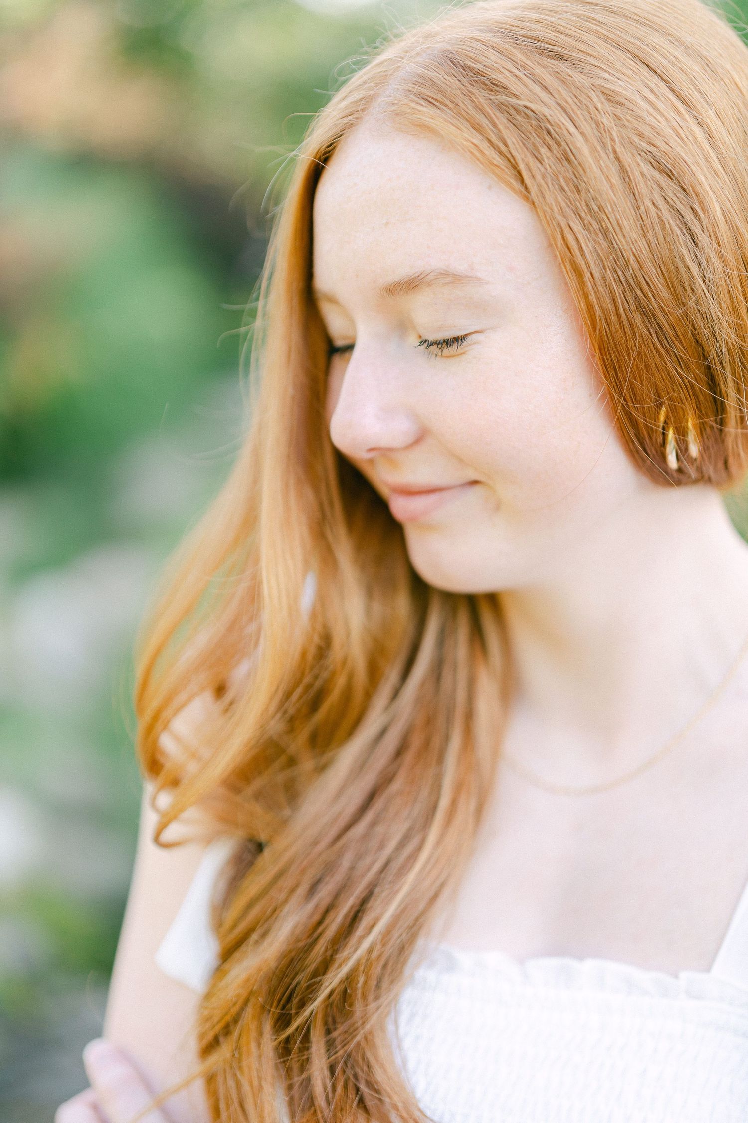 Ethereal portrait with soft lighting capturing long strawberry blonde hair and a gentle expression.